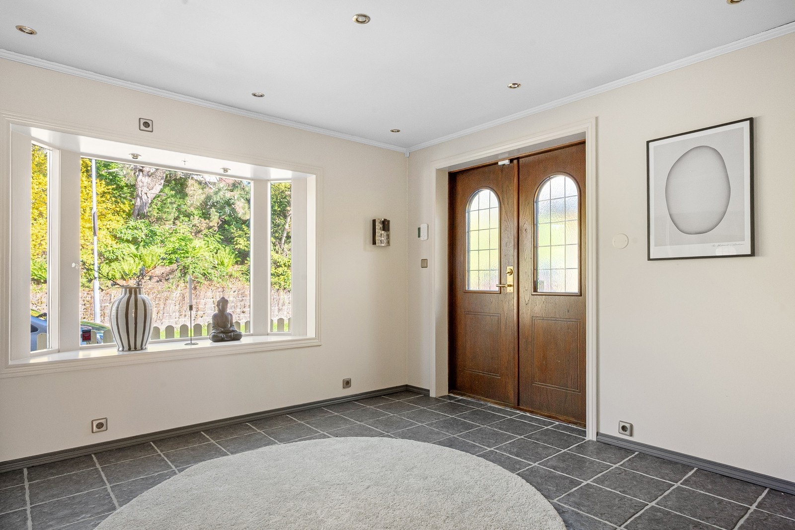 Inne tar en stor hall imot med flislagt gulv, downlights og koselig karnappvindu. Galleribilde