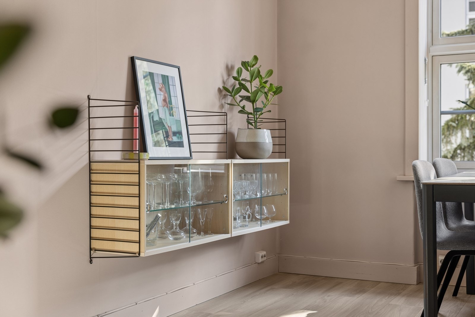 Lun og innbydende spisekrok med varme toner og praktisk oppbevaring langs veggen. Galleribilde
