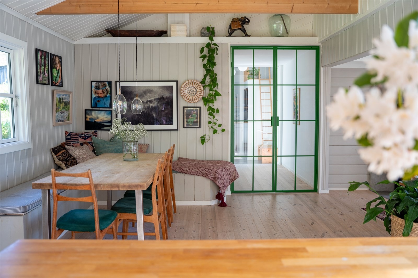 Spisestuen med langbord, den grønne glassdøren er montert i april 2026. Galleribilde