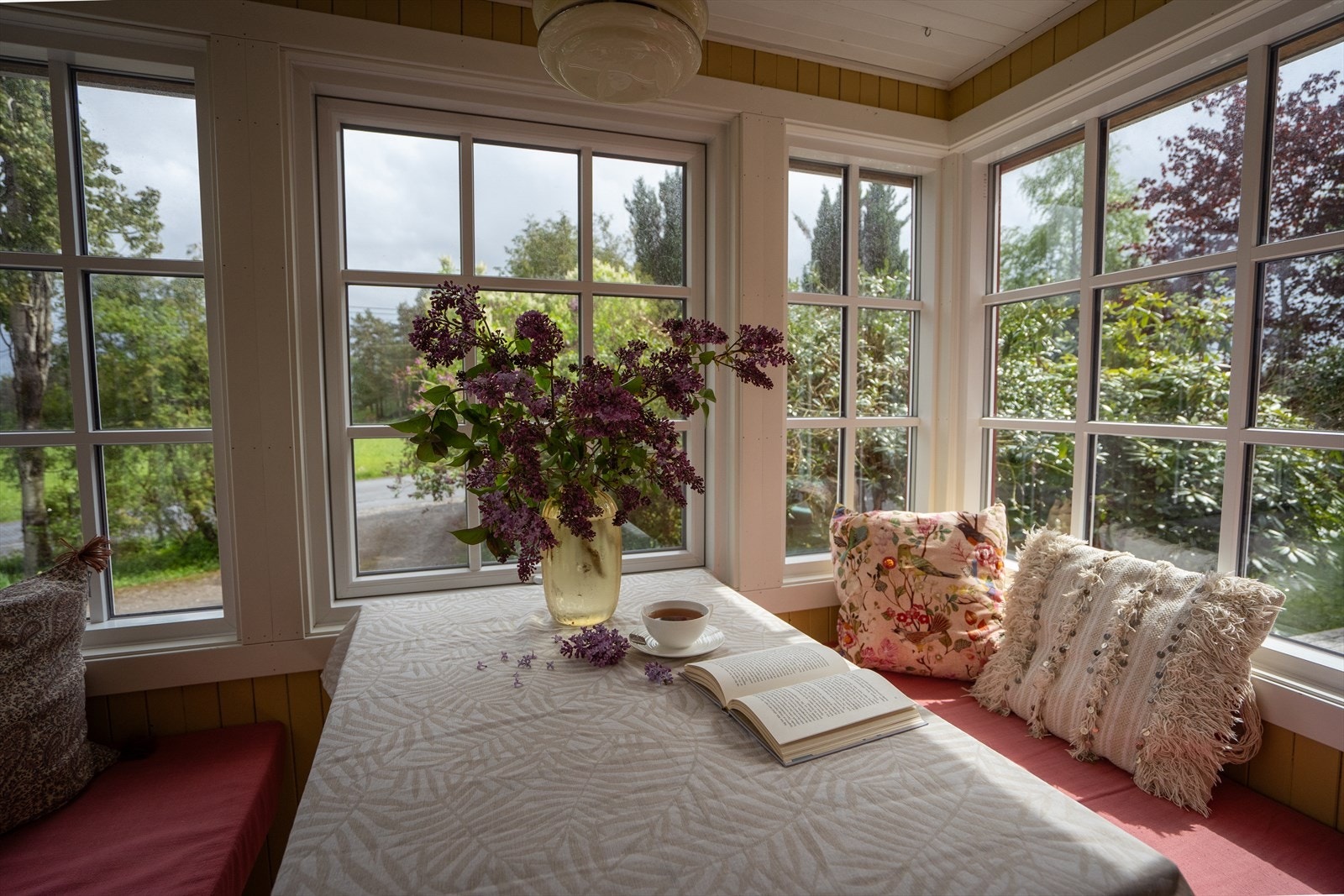 Glassveranda med sitteplass, syriner og utsyn mot hagen - en lun krok med sitteplass til 4. Galleribilde