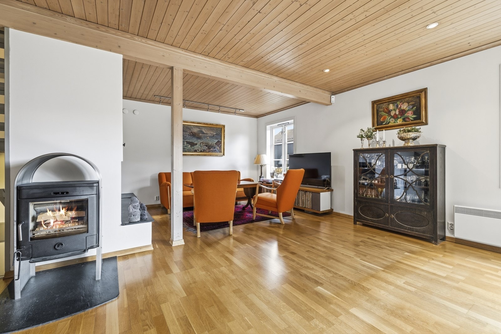 Stor og fin stue med parkettgulv, lysmalte veggflater og to ildsteder Galleribilde