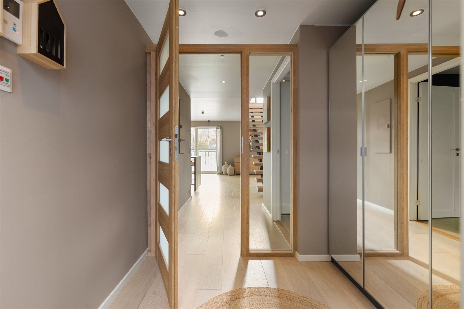 Stilig speilgarderobe i entreen, med trerammet glassdør som lukker av sonen. Galleribilde
