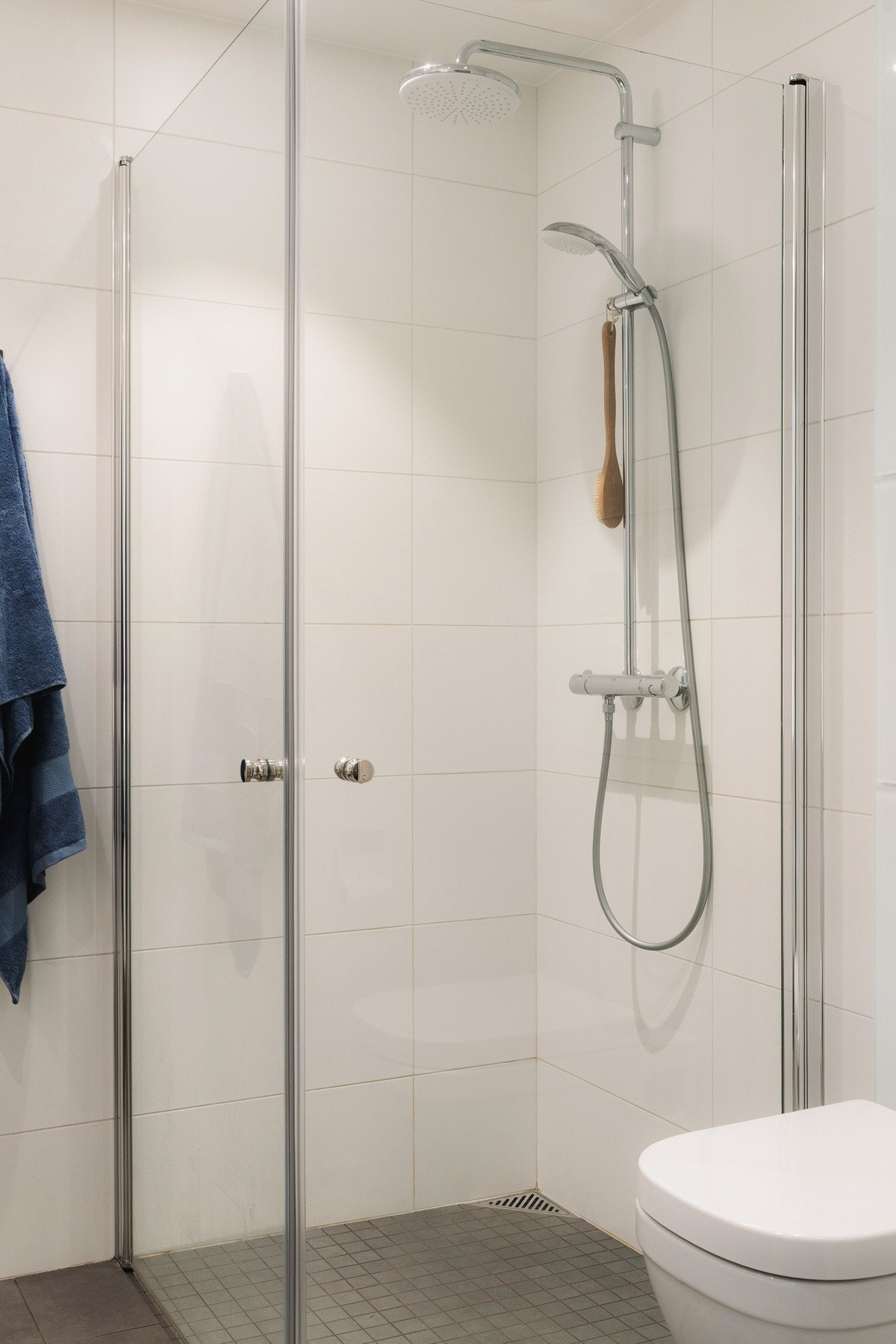 Videre er badet utstyrt med vegghengt toalett, dusjhjørne med innfellbare glassdører og opplegg for vaskemaskin. Galleribilde