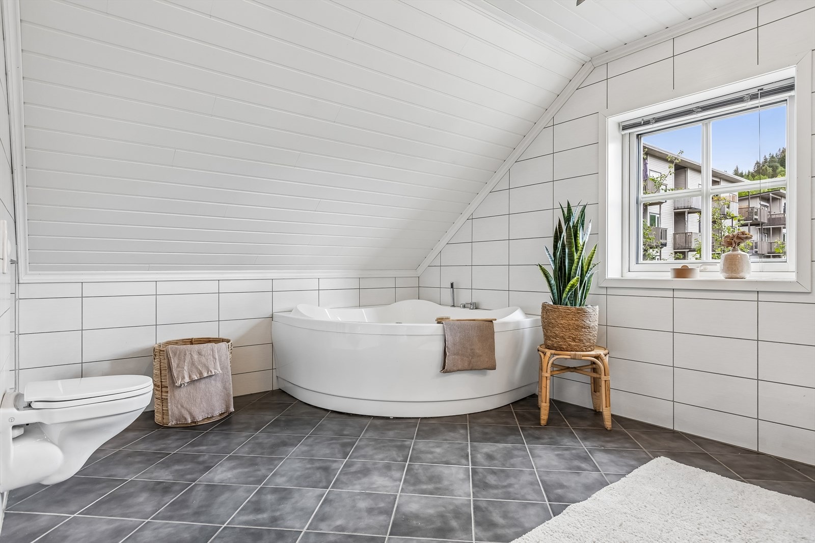 Badet er innredet med servant, badekar, vegghengt klosett, dusjnisje og mekanisk avtrekk. Galleribilde