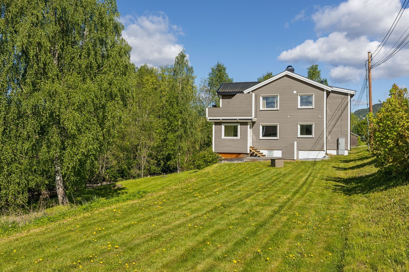 Eiendommen strekker seg over et solrikt areal på 1 689 m² langs elvebredden. Galleribilde