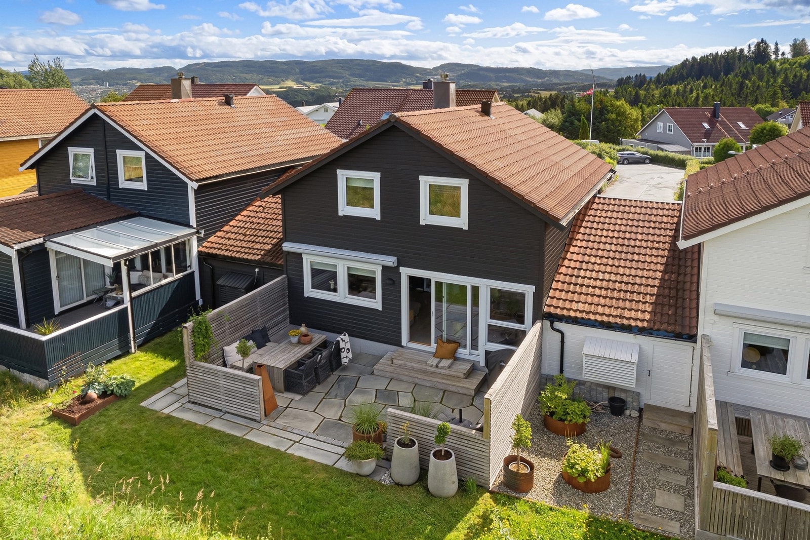 Innbydende og velholdt kjedehus med moderne uttrykk, skjermet uteplass og flotte uteområder som inviterer til hyggelige stunder utendørs. Galleribilde