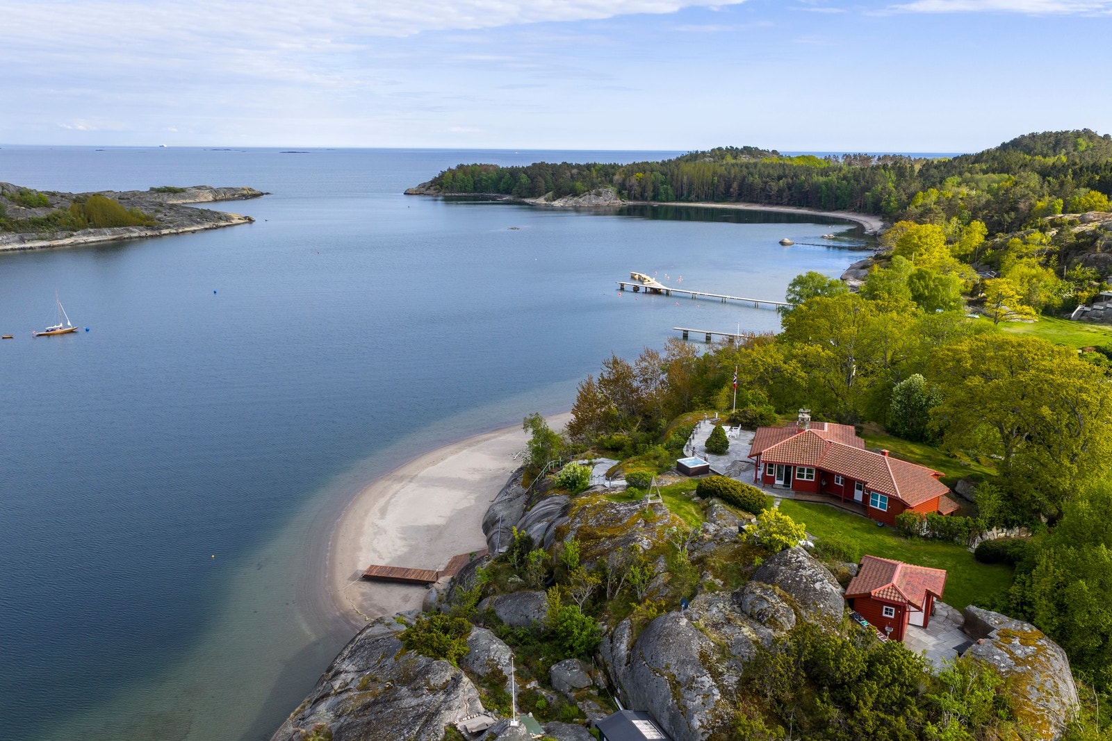 Unik naturtomt med opparbeidet beplantning og plen, sandstrand og bryggeanlegg Galleribilde