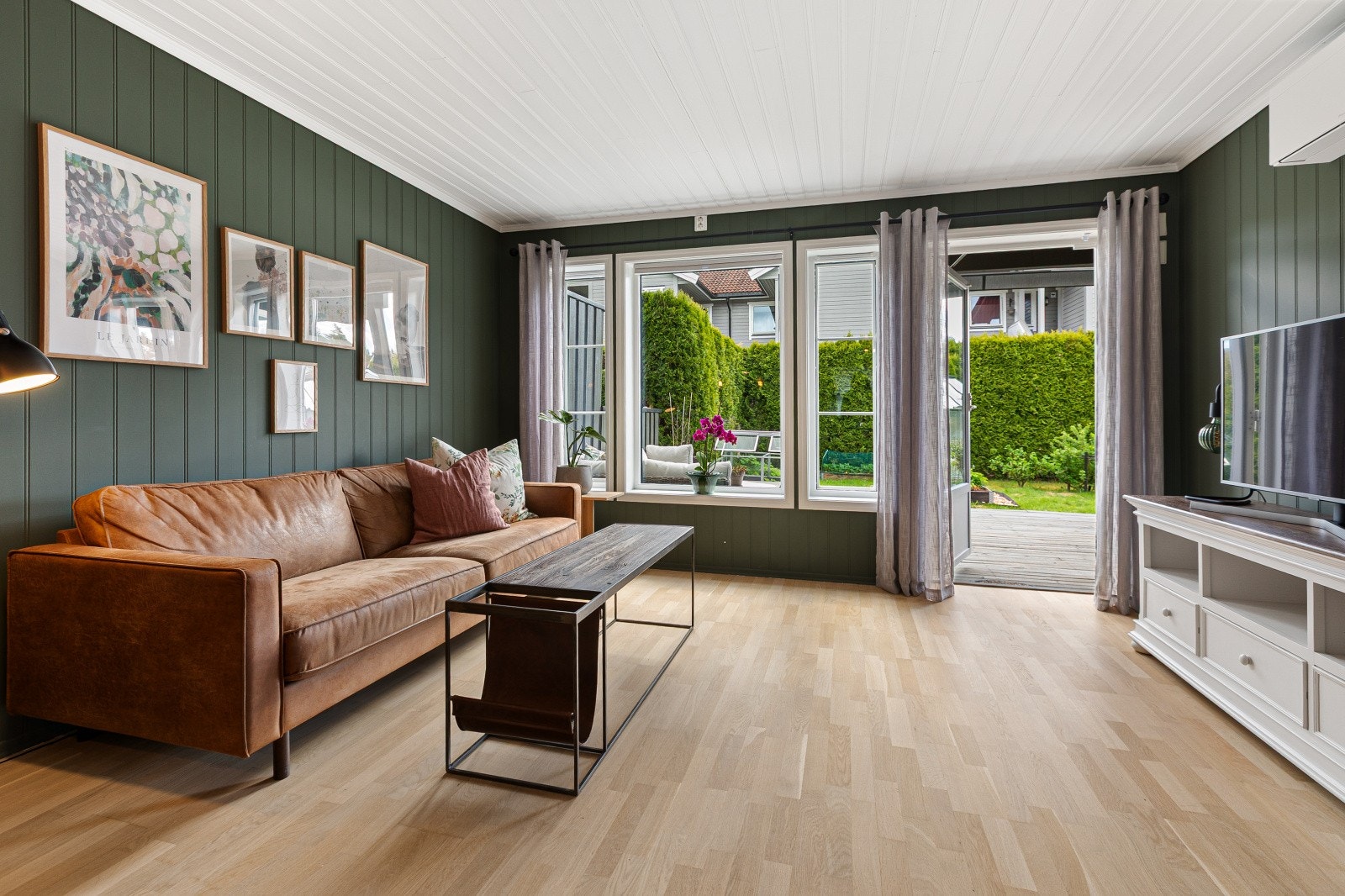 Store vindusflater slipper inn rikelig med dagslys og gir et fint utsyn mot hagen, samtidig som terrassedøren skaper en naturlig overgang til uteplassen. Galleribilde