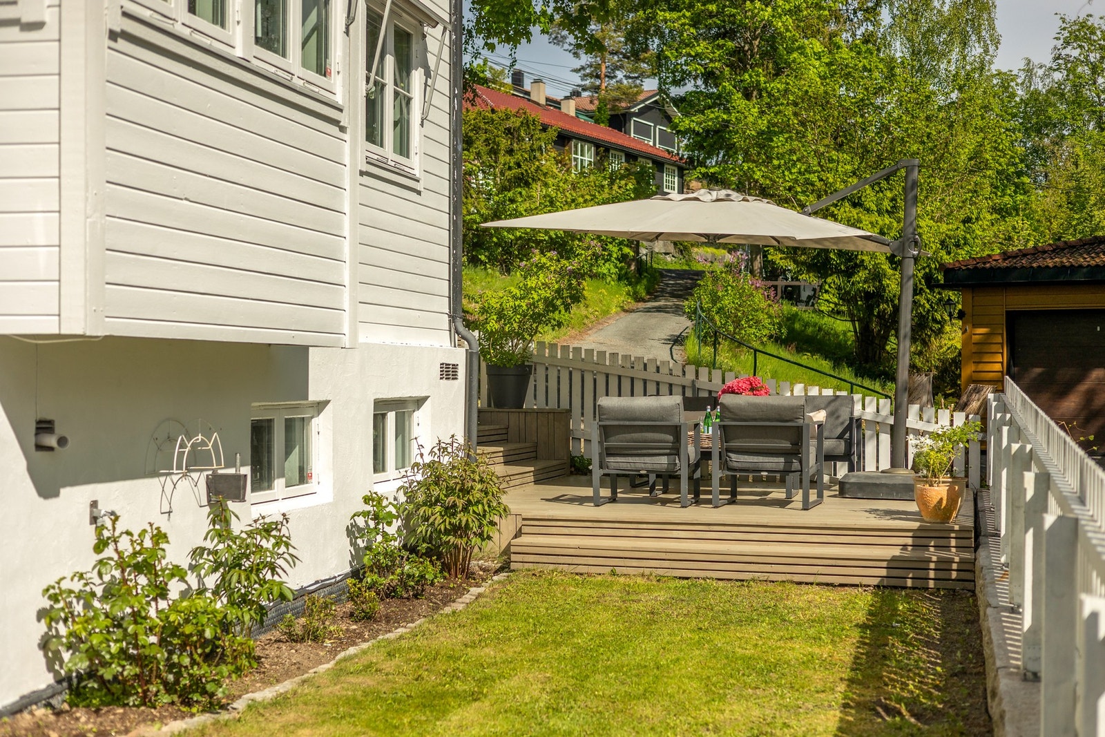 Hagen og uteområdene er lettstelte og pent opparbeidet med vakre rosebusker og variert beplantning som sikrer blomstring gjennom hele sommeren Galleribilde
