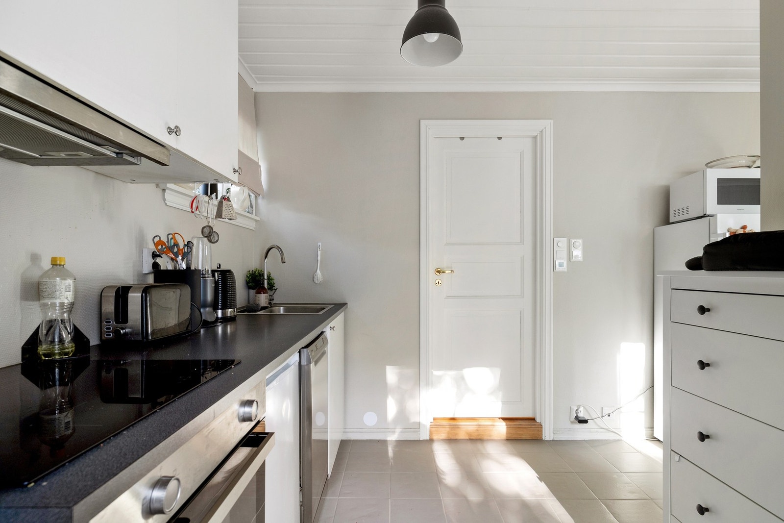 Kjøkkenet har innredning med glatte fronter og laminat benkeplate - Integrert i kjøkkeninnredningen er oppvaskmaskin, platetopp, stekeovn og komfyrvakt, kjøleskapet er plassert i egen nisje Galleribilde