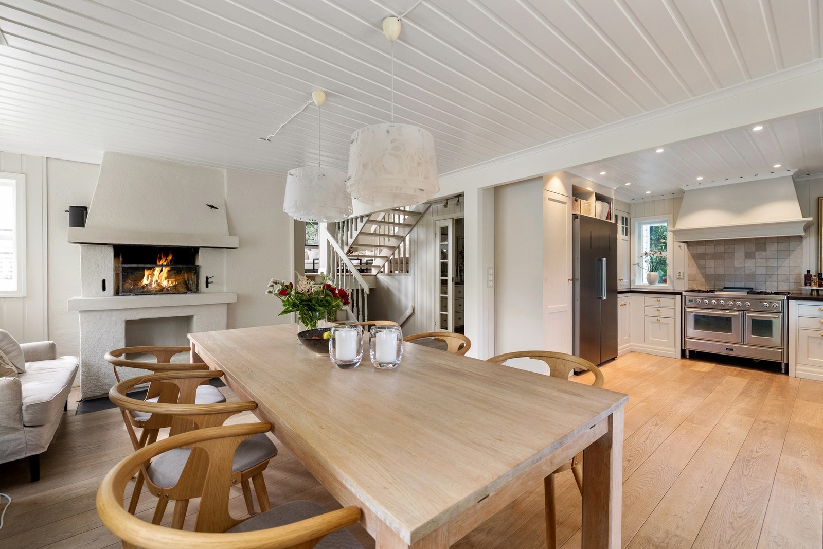 I spisestuen er det også egen sone med plass til sofa ved boligens andre peis Galleribilde