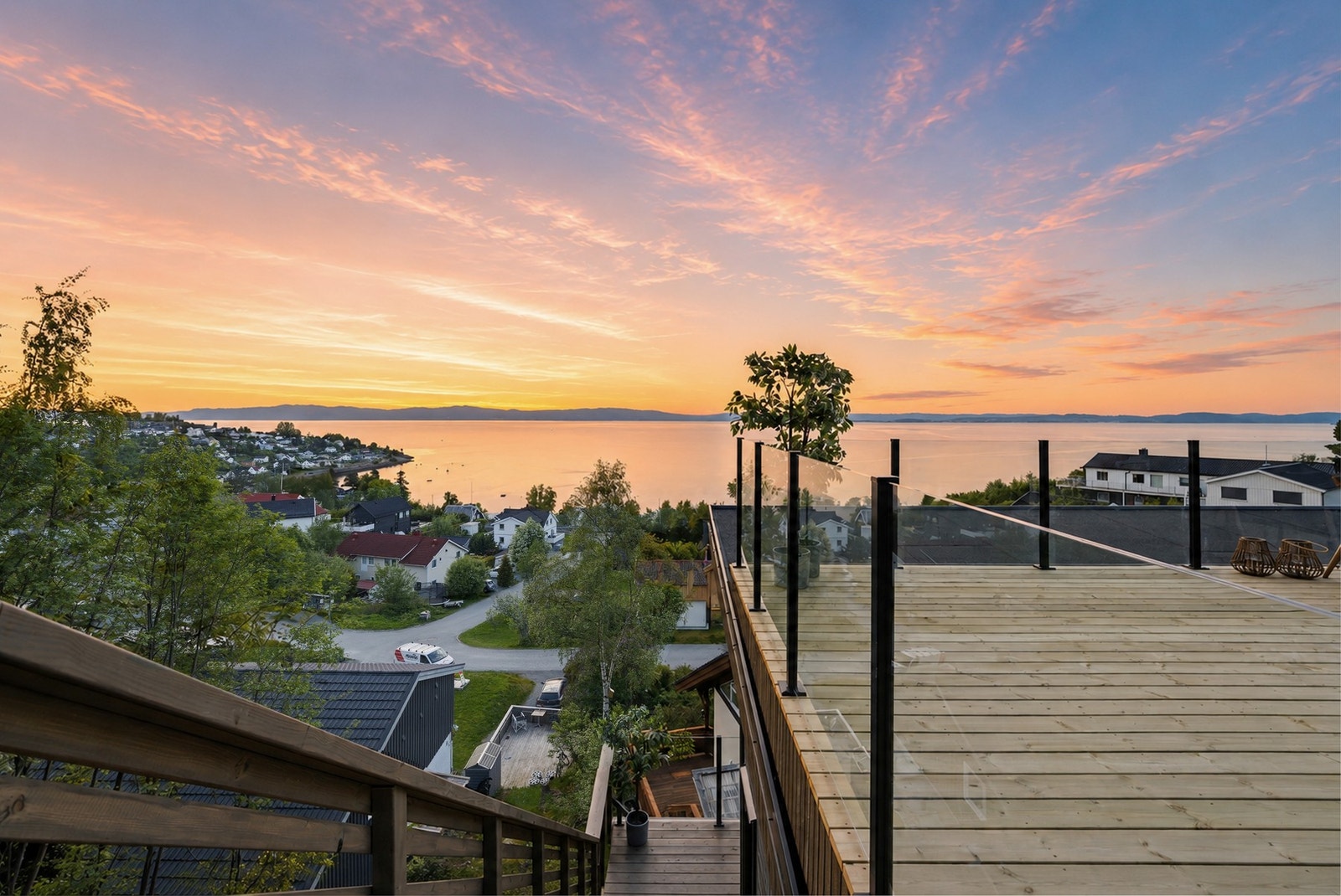 Her nyter du det herlige fargespillet som utspiller seg på himmelen og i gjenskinnet i fjorden ved solnedgang. Galleribilde