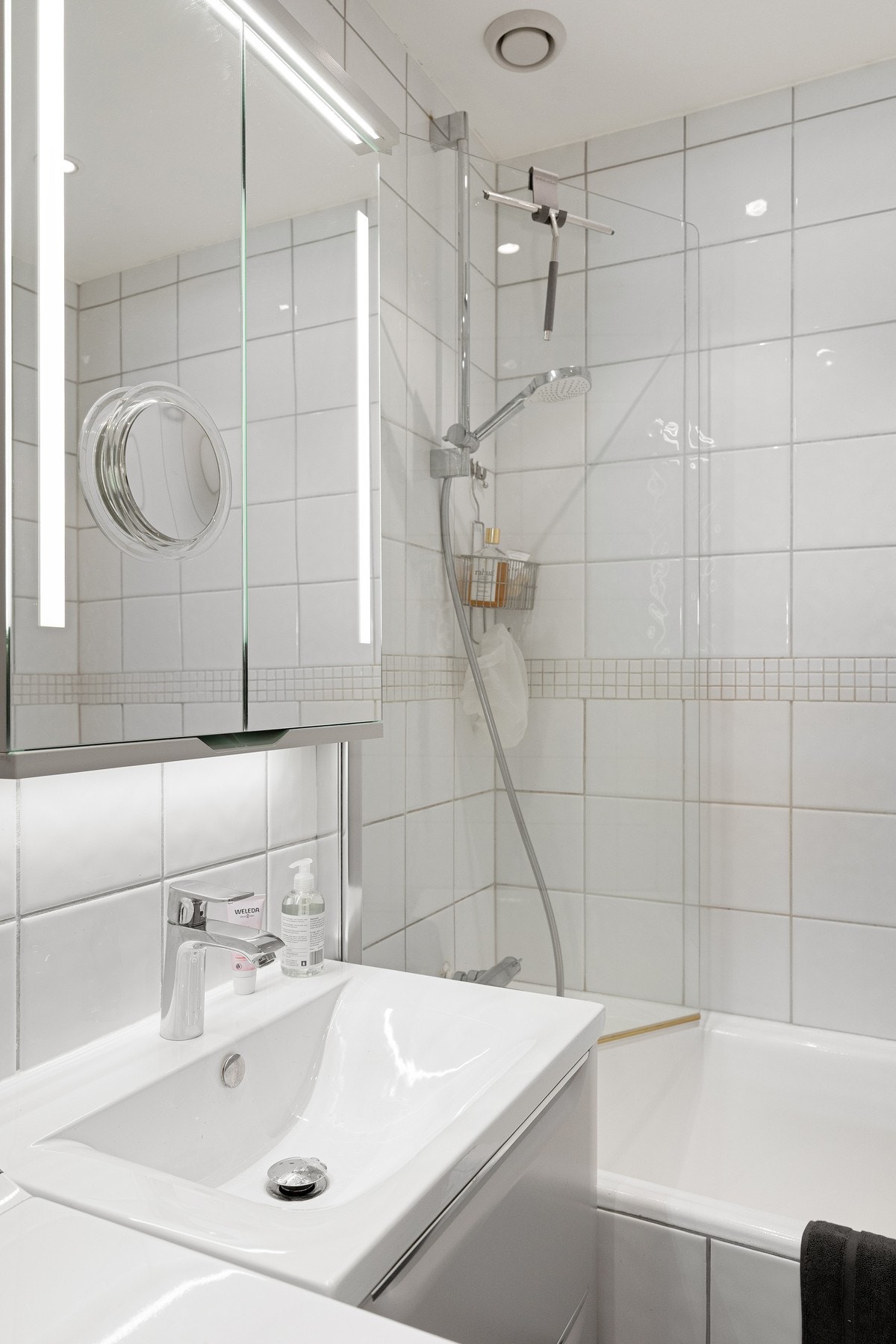 Badet er innredet med badekar med dusjløsning, nedfelt servant med underskap og speilskap. Galleribilde
