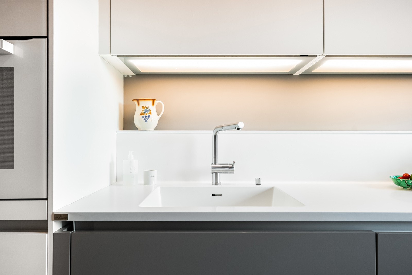 Delikat benkeplate i Corian og armatur i stål. Videre følger påkostede, integrerte hvitevarer fra Siemens og Miele Galleribilde