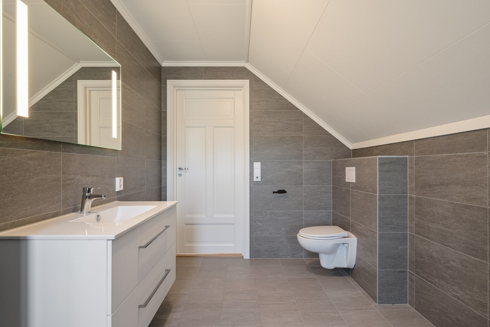 Badet i andre etasje er helfliset og har innredning med nedfelt servant og veggmontert toalett. Galleribilde