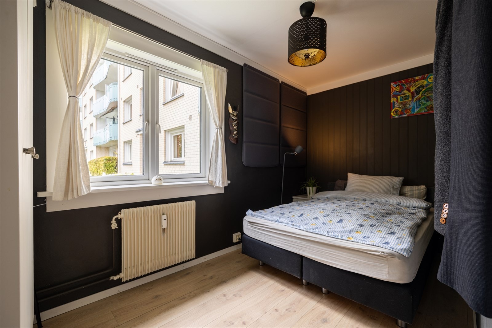 Soverom med vindu mot uteområdet og radiator tilknyttet vannbåren varme Galleribilde