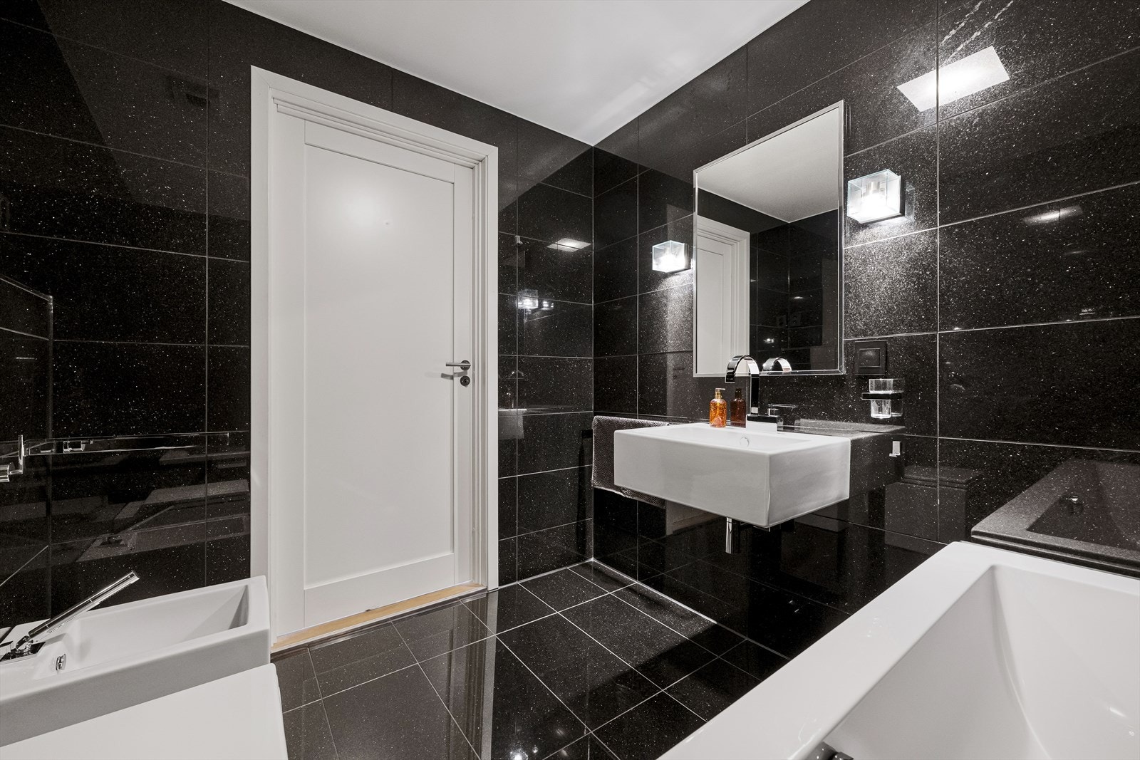Hovedbadet er utstyrt med innfliset badekar, bidet og vegghengt toalett. Galleribilde