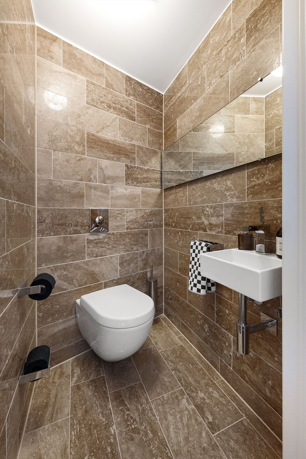Separat toalettrom med vegghengt toalett og servant, praktisk for gjester. Galleribilde