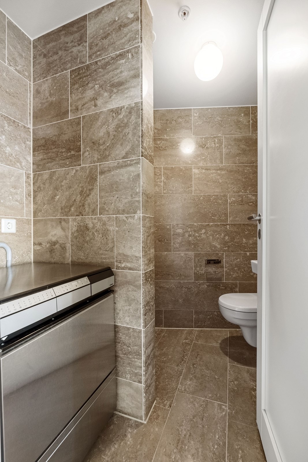 Badet har vegghengt toalett med skjult sisterne. Galleribilde