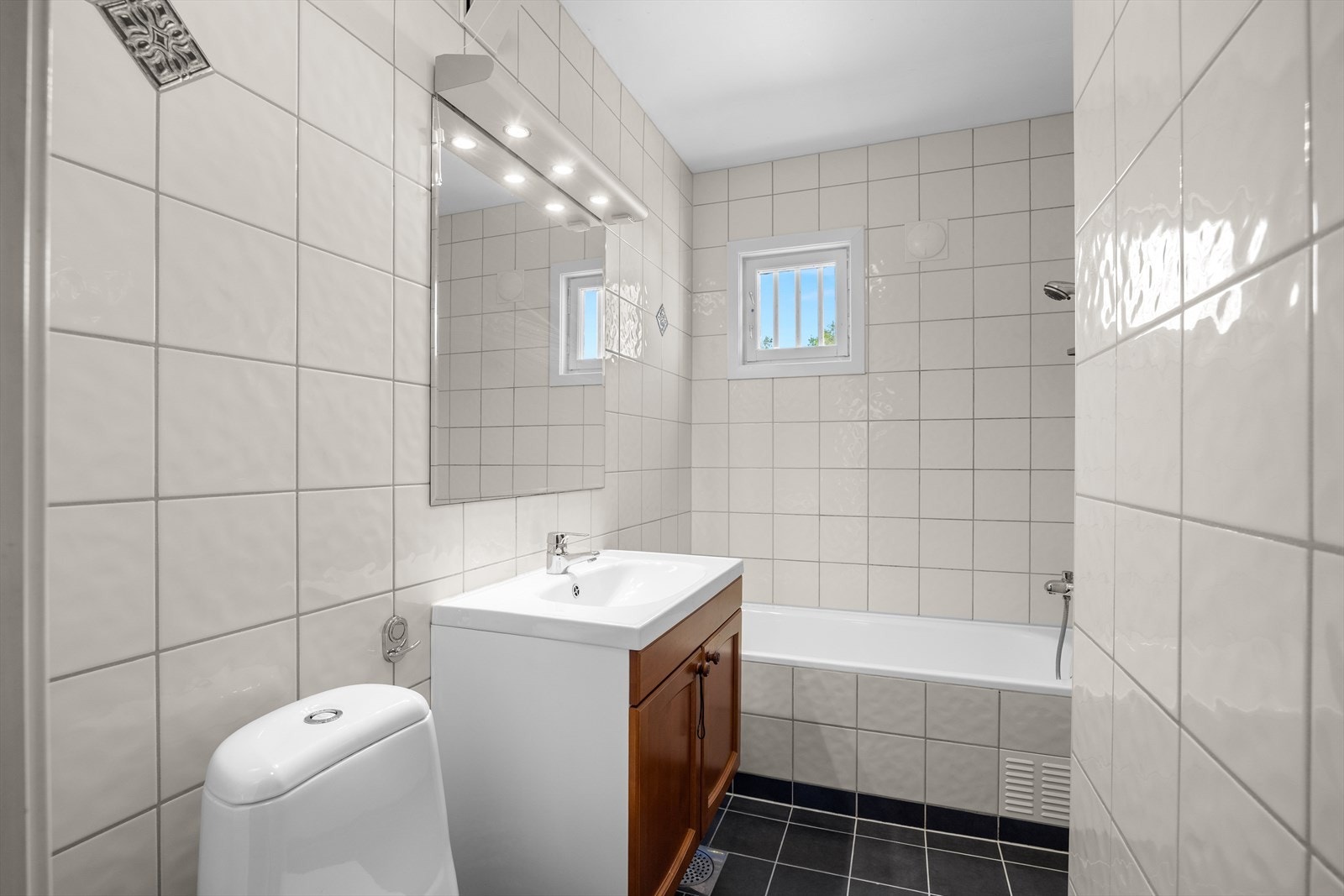 Helfliset bad i 2. etasje med varmekabler i gulv og lite vindu. Badet er innredet med toalett, badekar og baderomsinnredning. Badet ble pusset opp i 2003 Galleribilde