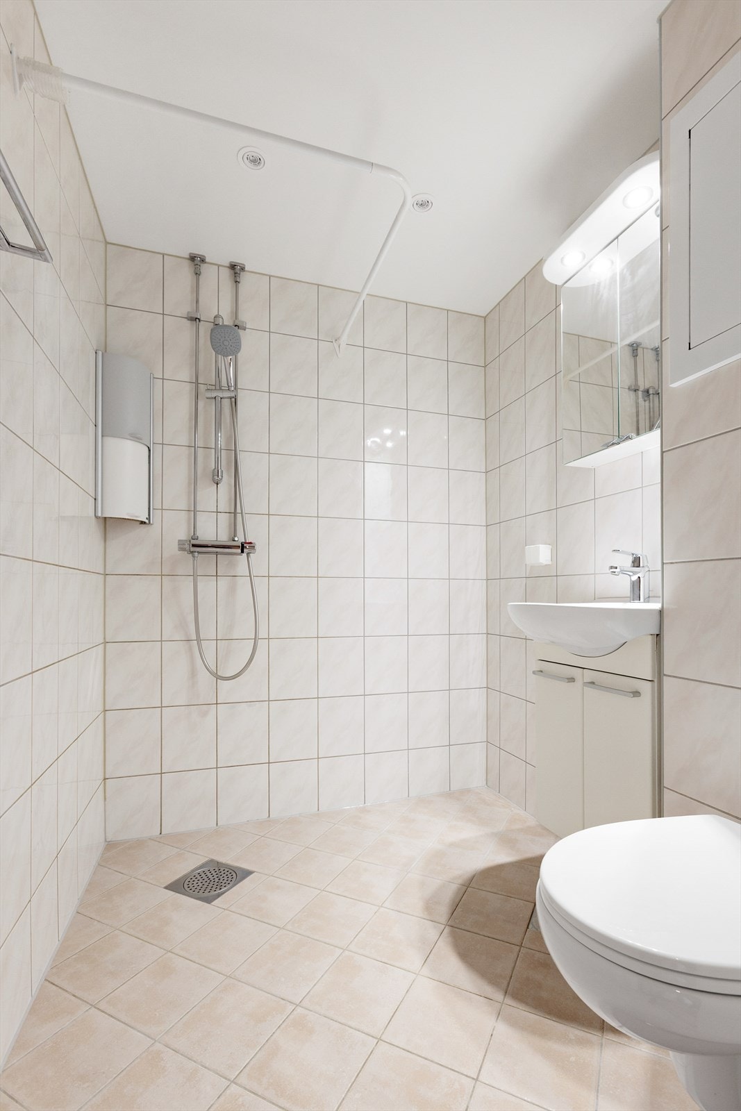 Badet er utstyrt med innfelte downlights i taket og en åpen dusjløsning. Galleribilde