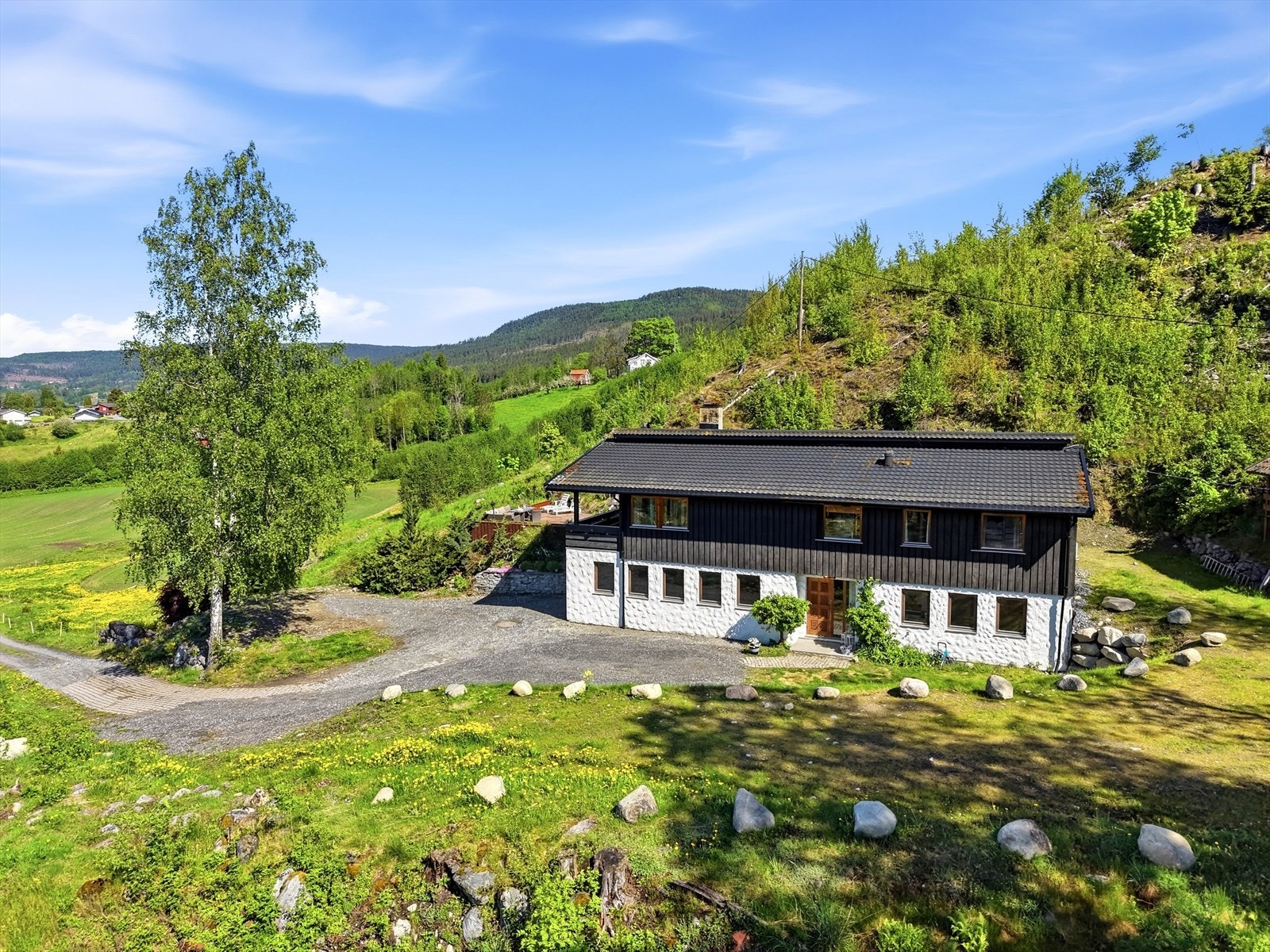 Enebolig fra 1977 med stående bordkledning og taktekking av steinbelagte stålplater fra 2008. Galleribilde