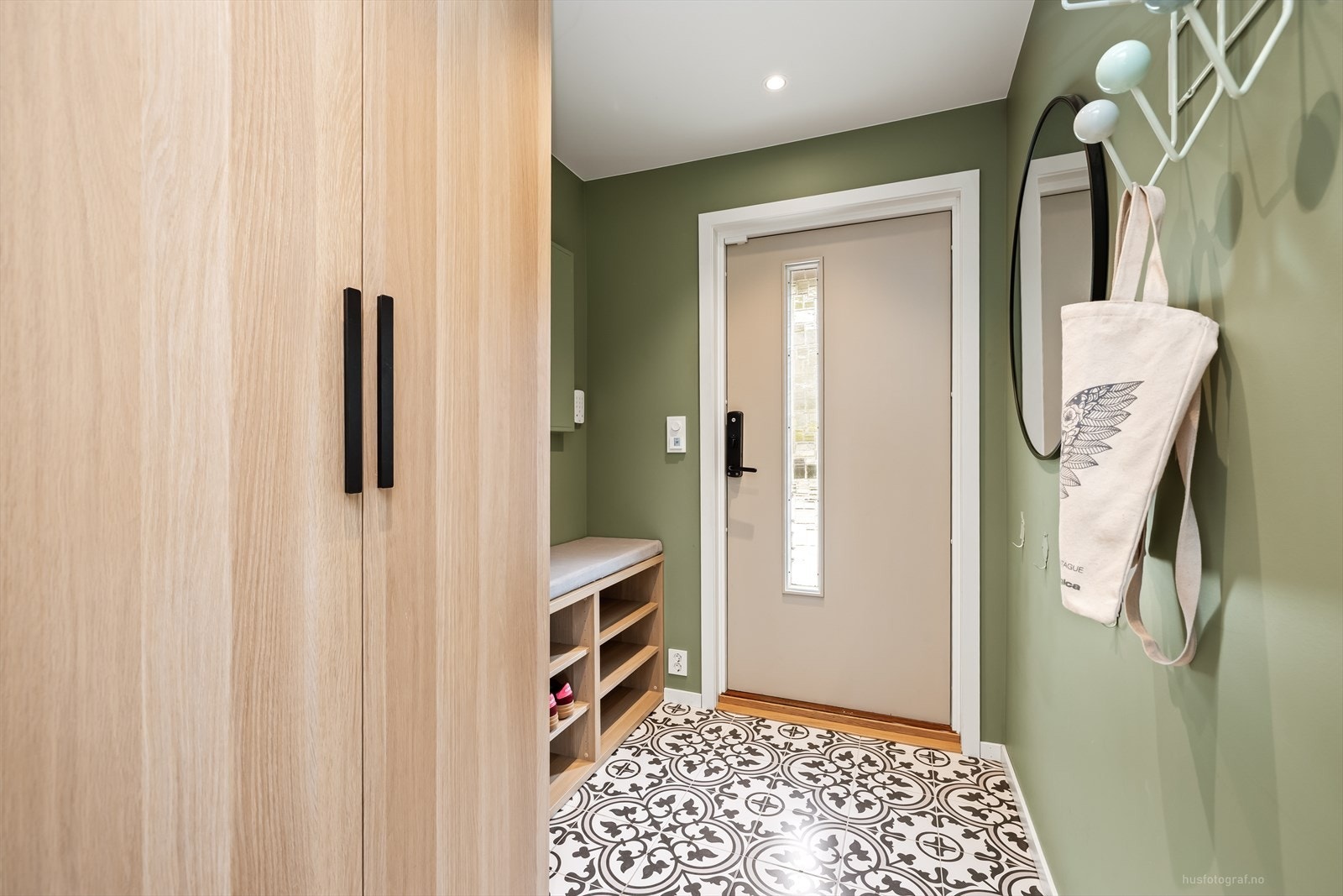 Velkommen inn til en lys og romslig entré med en mønstret keramisk flis på gulv. Det er god plass til oppheng for yttertøy og til å sette ifra seg sko, i garderobeløsning noe som gjør det enkelt å holde orden i inngangspartiet. Galleribilde