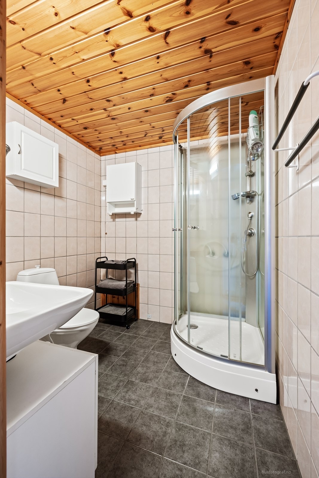 Badet er utstyrt med toalett, servant og dusjkabinett. Galleribilde