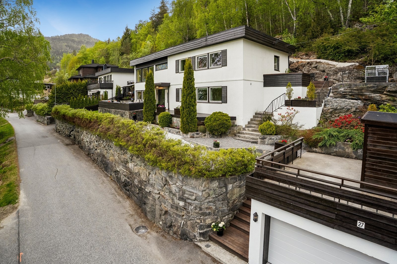 Uteområdet er pent opparbeidd med flatt og fint plenareal, markterrasser i ulike nivå, natursteinmurar, hekk som omkransa eigedomen og diverse prydbeplantning. Galleribilde