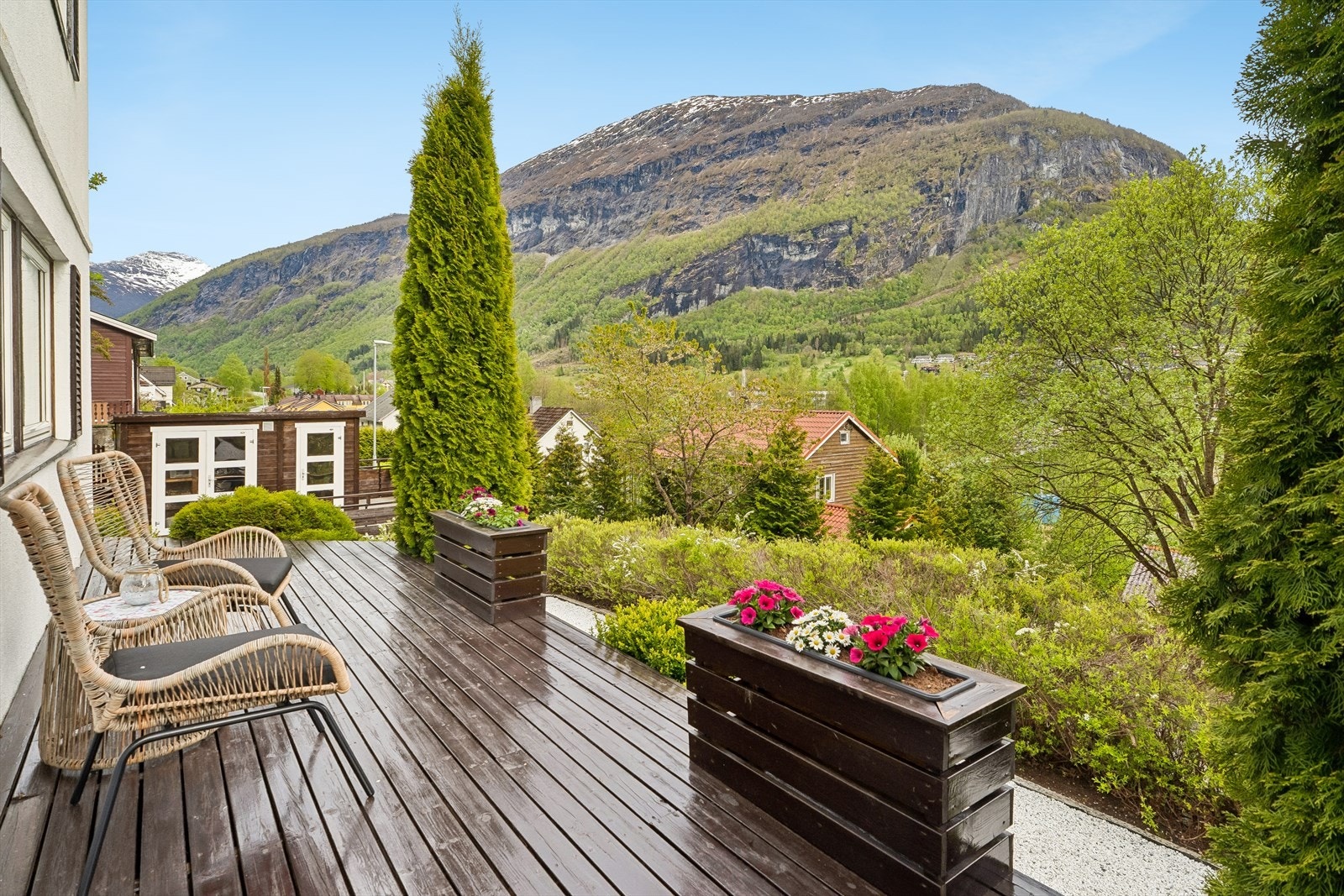 Inngangspartiet ynskjer deg velkomen med markterrasse, grusa veg og fine detaljar i naturstein og flotte blomsterkasser. Galleribilde
