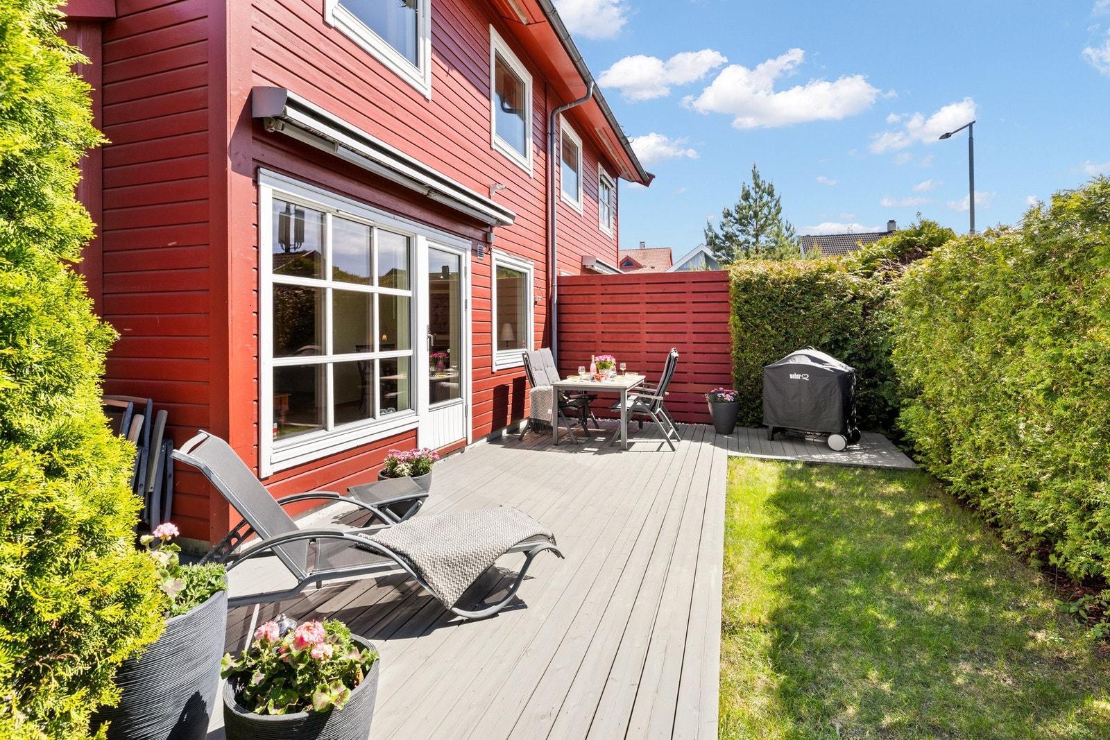 Idyllisk uteområde med sydvendt terrasseplatting og hage. Galleribilde