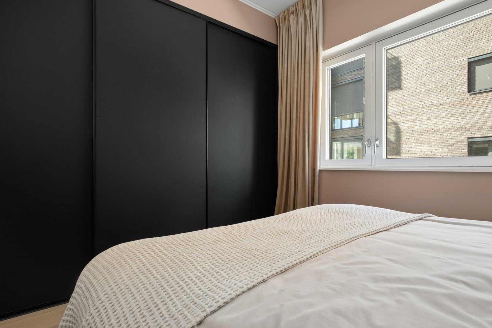 På hovedsoverommet er det en bred, plassbygd skyvedørsgarderobe med sorte fronter. Galleribilde
