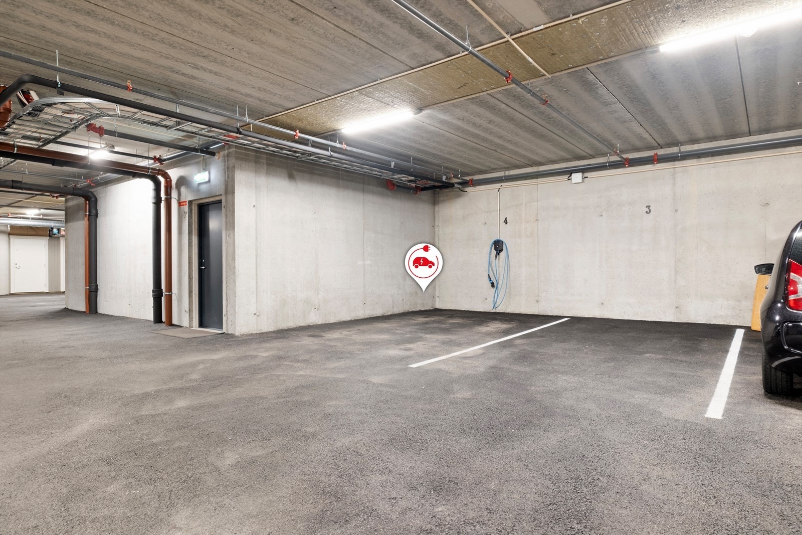 Fast endeparkering i garasjekjellar med elbil ladar. Galleribilde
