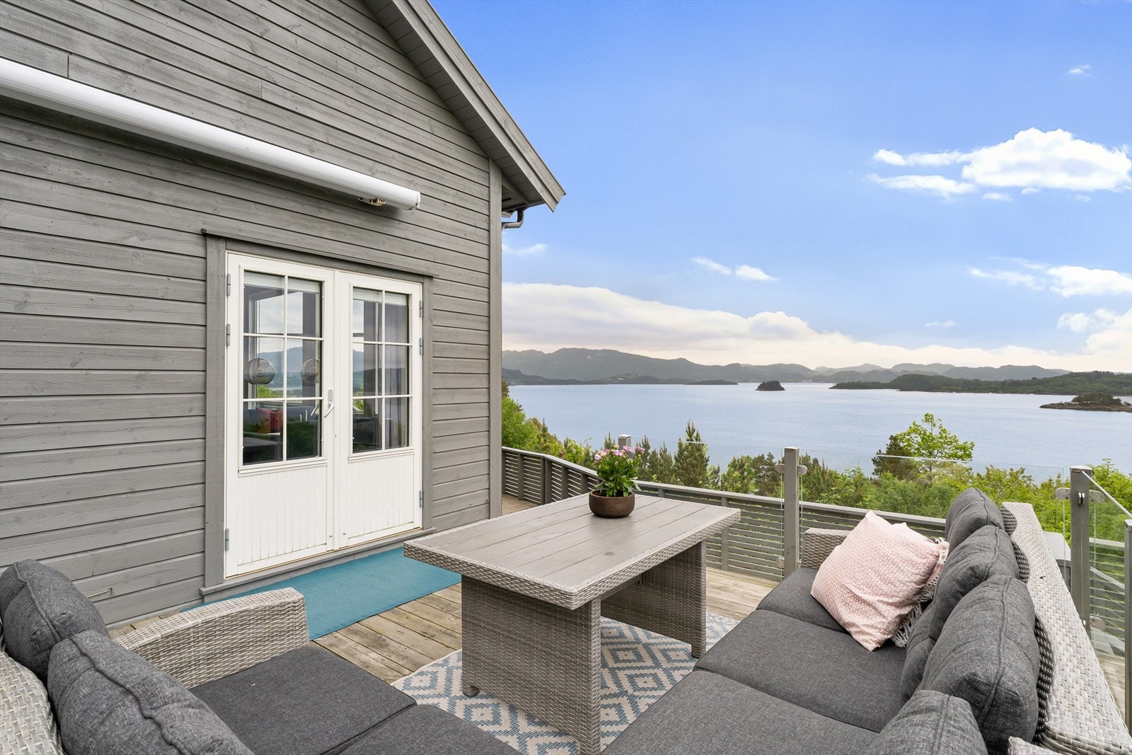 Terrasse med utgang fra stuen gir rikelig med plass for uteliv med utsikt over fjorden. Galleribilde