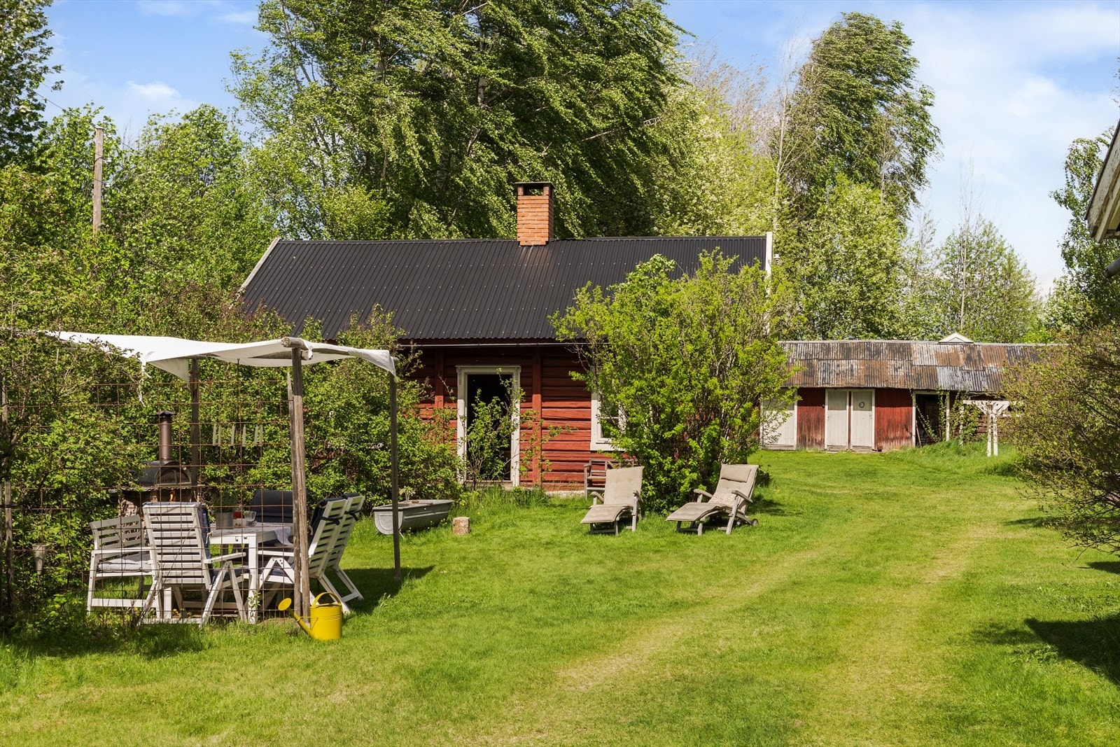 Det uimotståelige tunet har god plass for flere soner, for den som liker å nyte tilværelsen utendørs. Mot veien er det en høy syrinhekk, i tillegg til at det er en del trær og beplantning ellers på tomten. Galleribilde