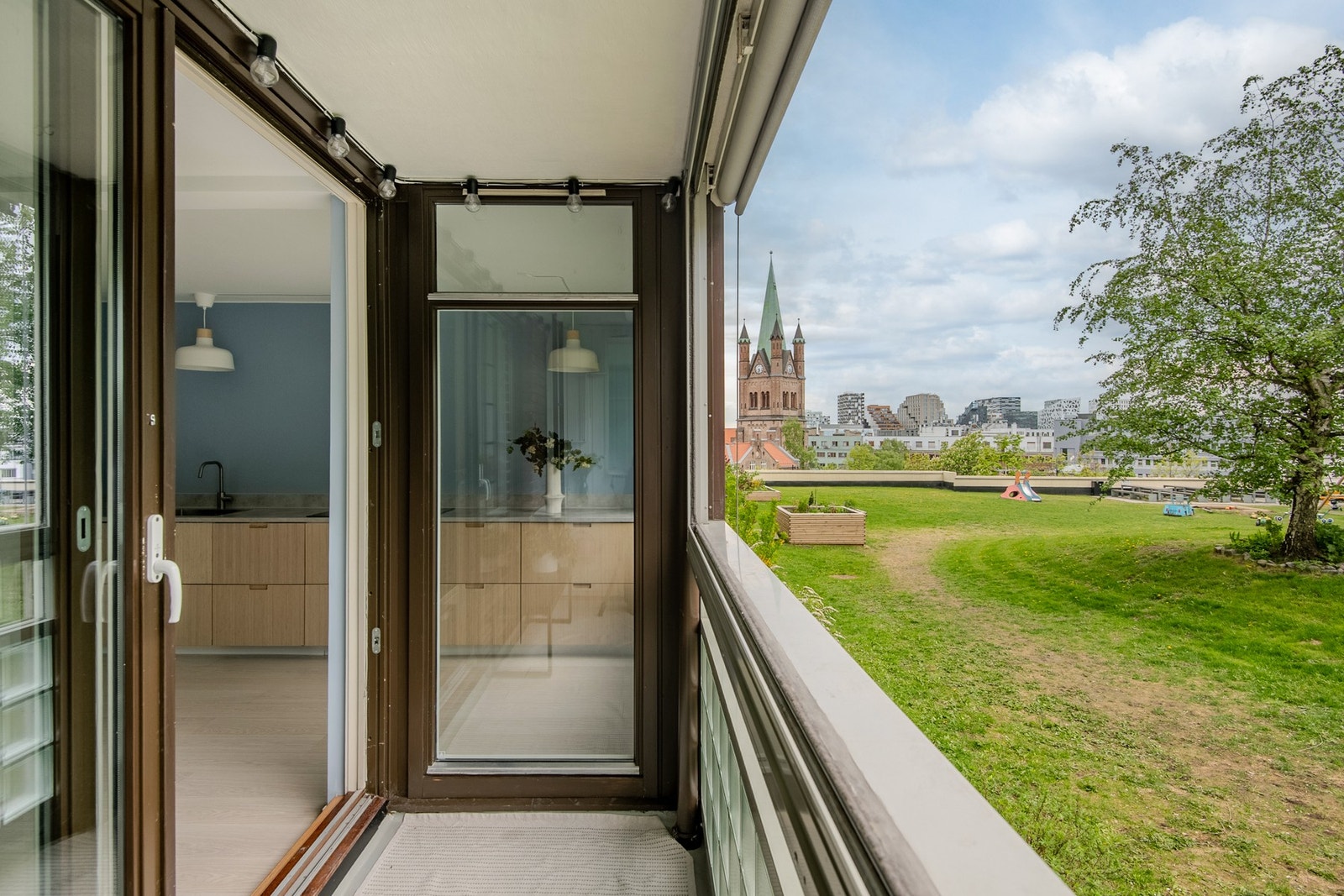 Fra den vestvendte, innglassede balkongen nyter man en flott utsikt over borettslagets grønne uteområder og Grønland Kirke. Balkongen på ca. 5 kvm har glassvinduer som kan foldes inn og gir gode muligheter for bruk av balkong året rundt. Galleribilde