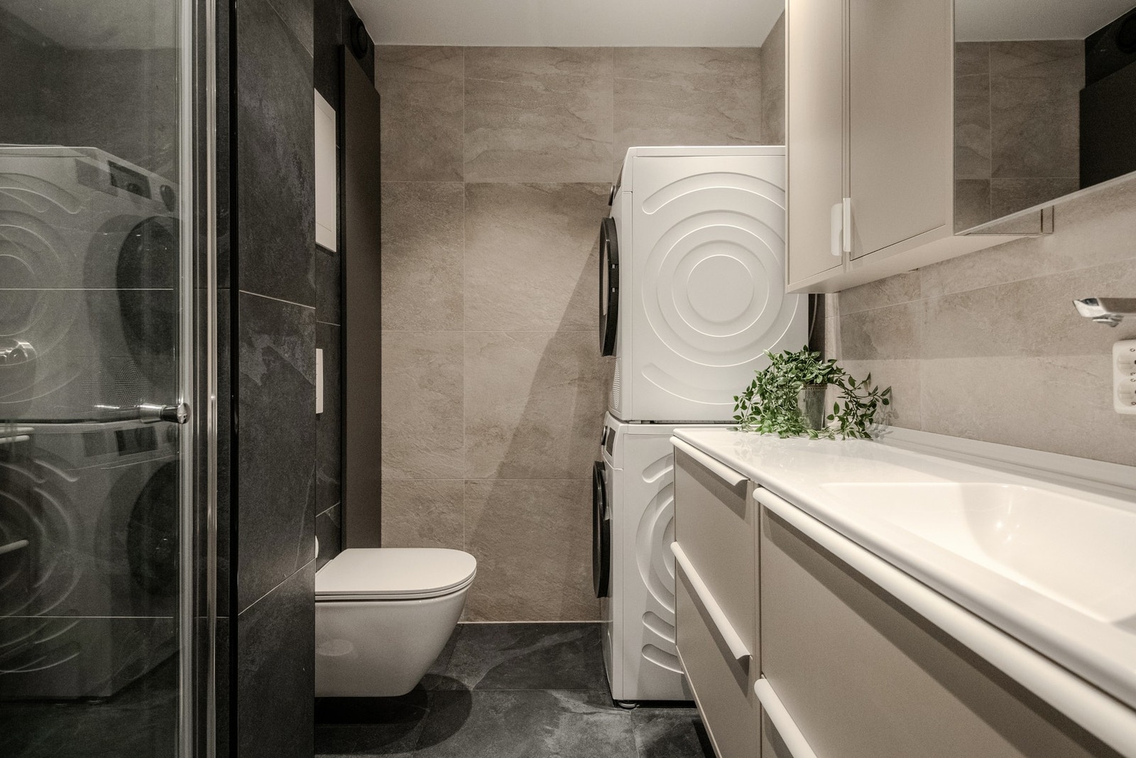 Badet fremstår som moderne og gjennomført etter totalrenovering i 2024. Et integrert og romslig høyskap gir ekstra oppbevaringsplass til håndklær, toalettsaker og rengjøringsutstyr. Galleribilde