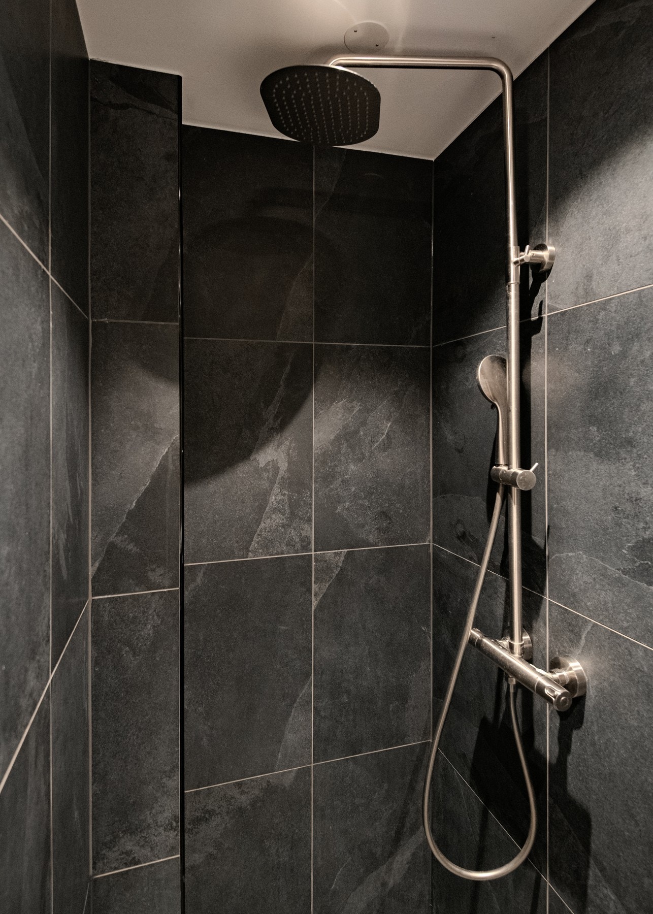 Badet er utstyrt med regndusj og flislagte vegger som gir et eksklusivt og tidløst uttrykk. Galleribilde