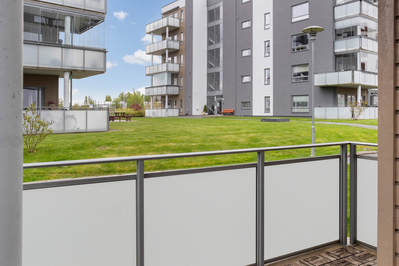 Fra uteplassen er det utsikt over sameiets fellesarealer med gressplen og beplantning. Galleribilde