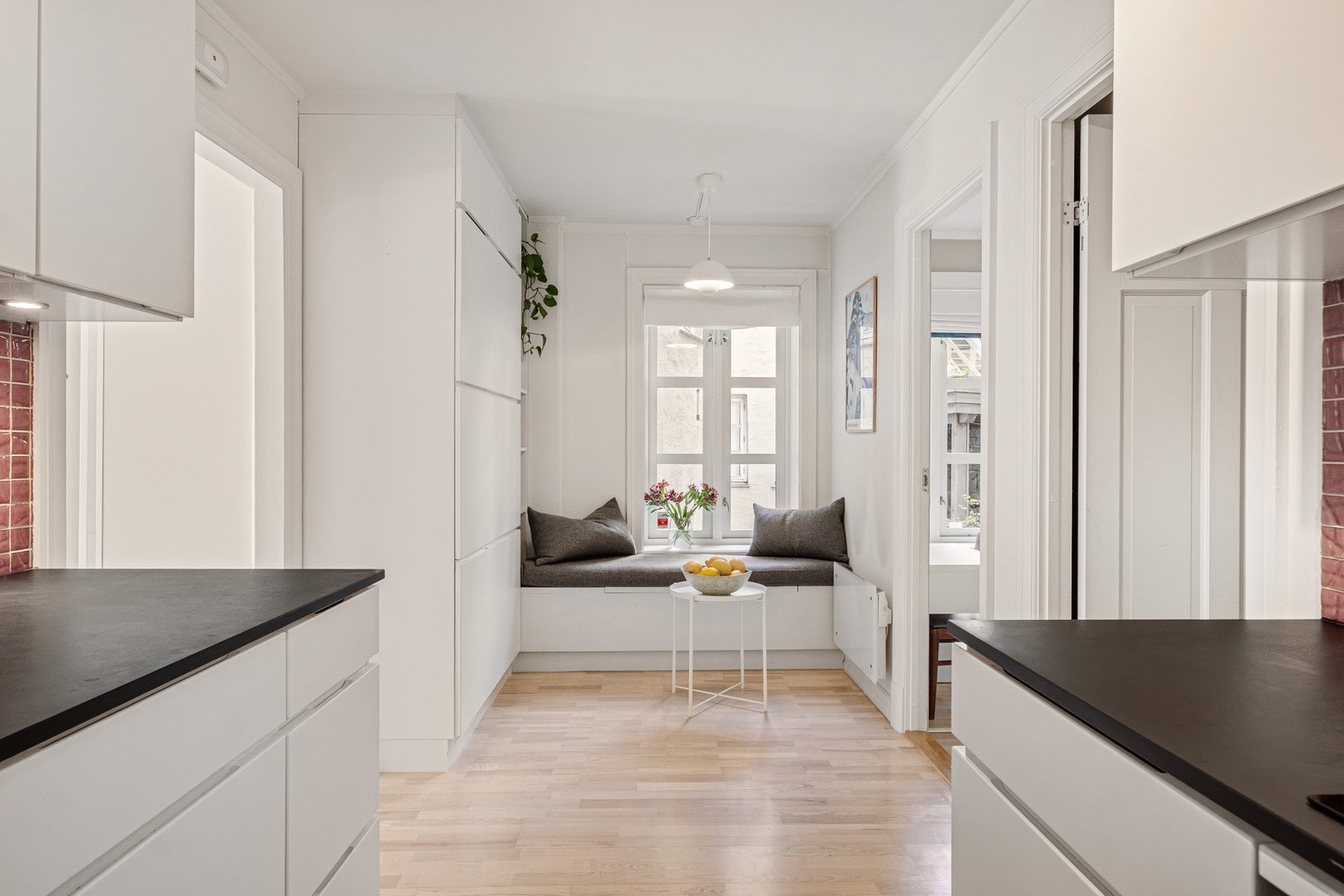 Den plassbygde benken under vinduet på kjøkkenet har tilpassete puter og følger boligen. Galleribilde
