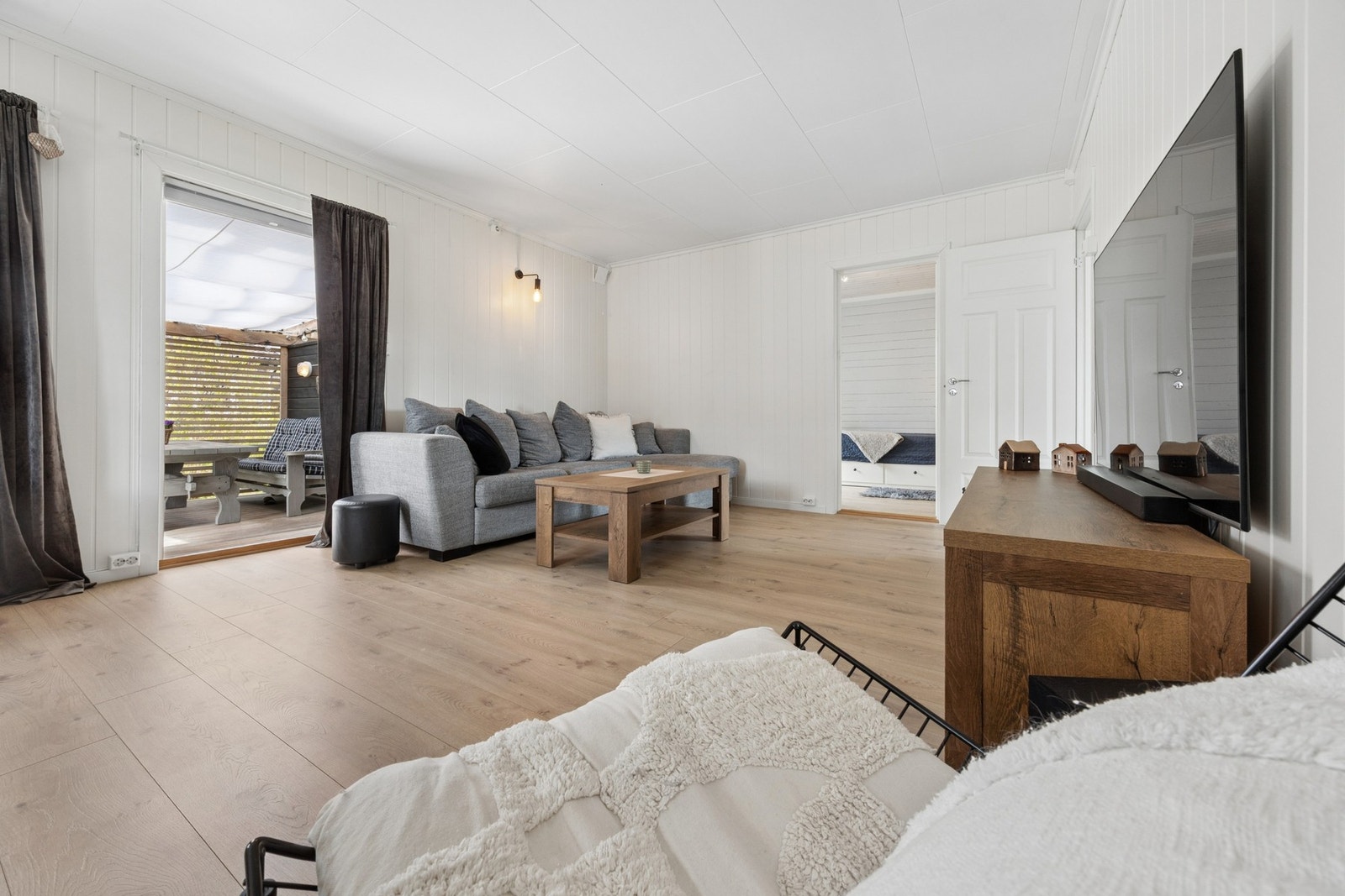 Store vindusflater slipper inn rikelig med dagslys og gir rommet en åpen og innbydende atmosfære. Galleribilde