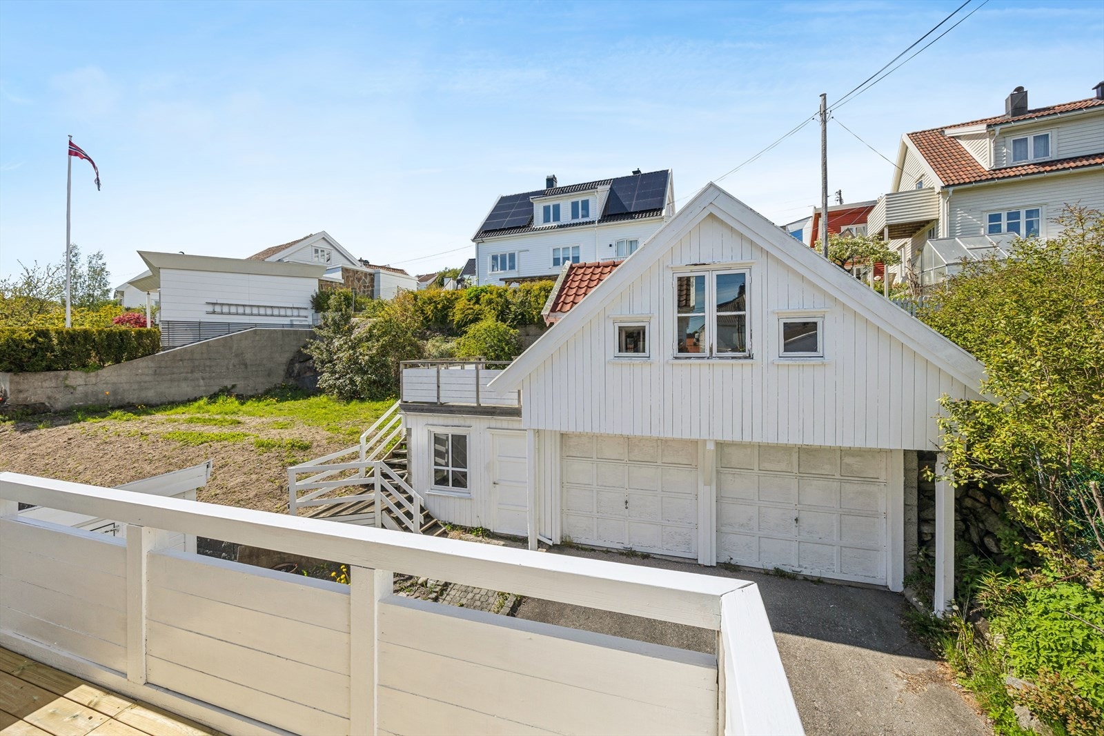 Fra terrassen ser man opp mot Fagertun. Egen dobbel garasje med loft og terrasse i tilknytning til loftet. Galleribilde