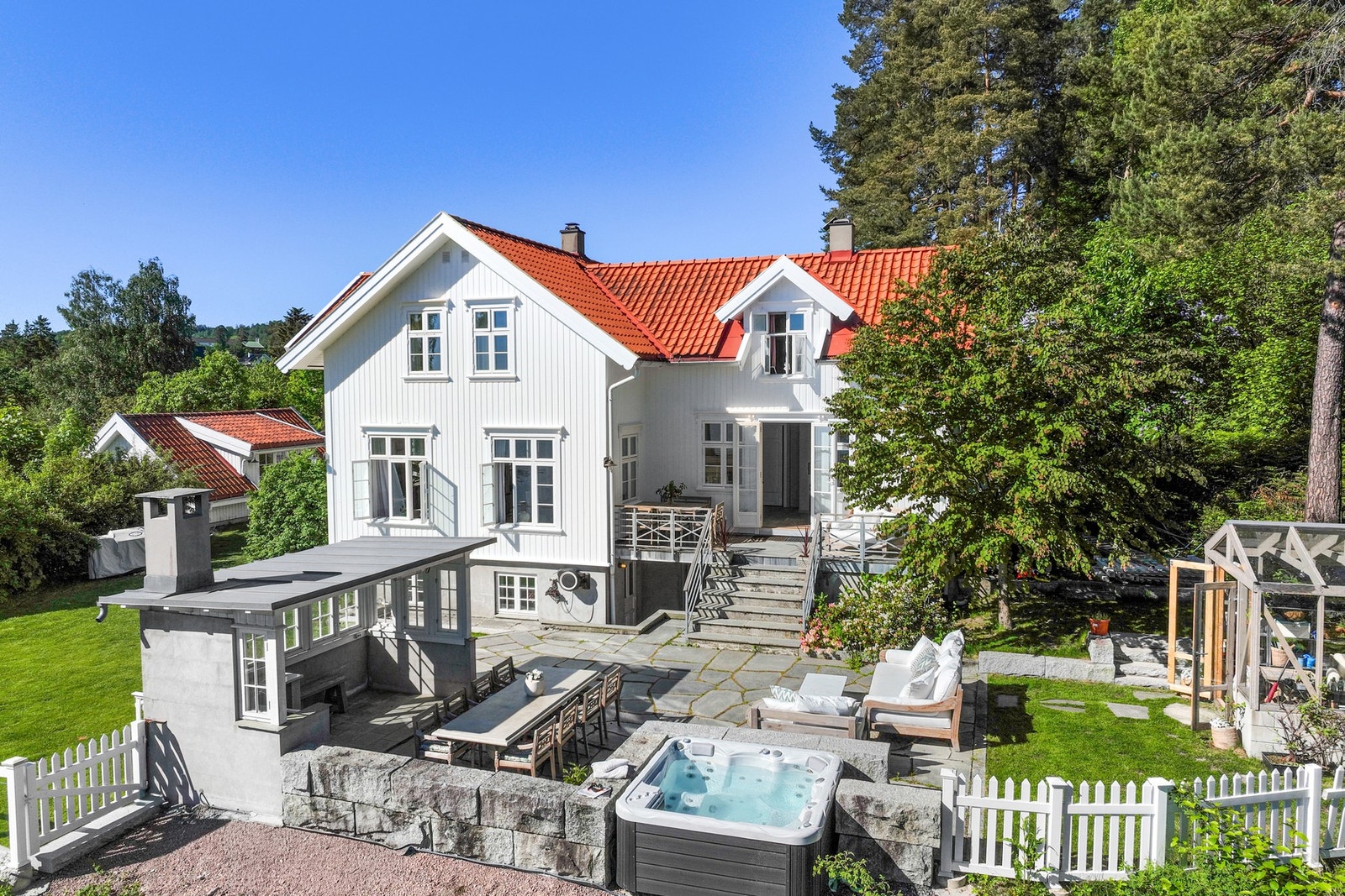 Eiendommen byr på flotte uteområder med flere oppholdsplasser, jacuzzi, hagestue og store terrassearealer. Her ligger alt til rette for lange sommerdager og hyggelige sammenkomster med familie og venner. Galleribilde