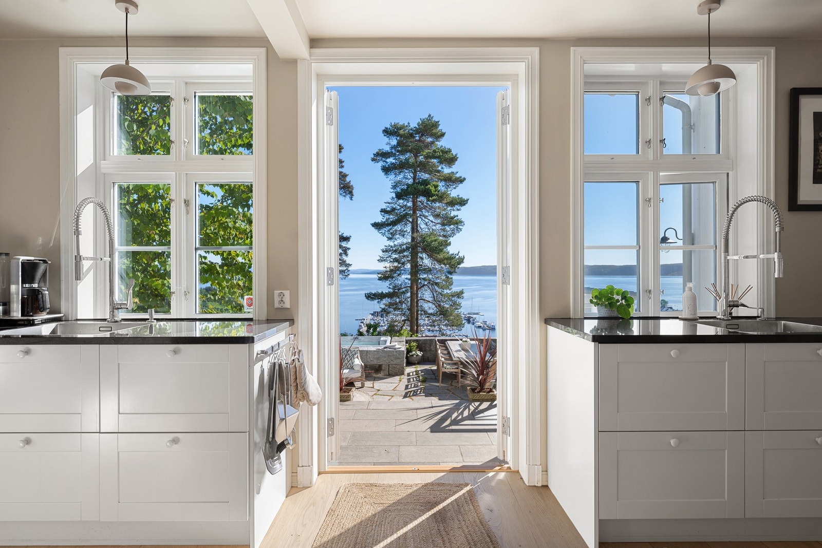 Et lyst og innbydende kjøkken hvor store vindusflater rammer inn den flotte utsikten mot fjorden. Terrassedøren gir enkel tilgang til uteplassen og skaper en sømløs overgang mellom inne- og uteområdene. Galleribilde