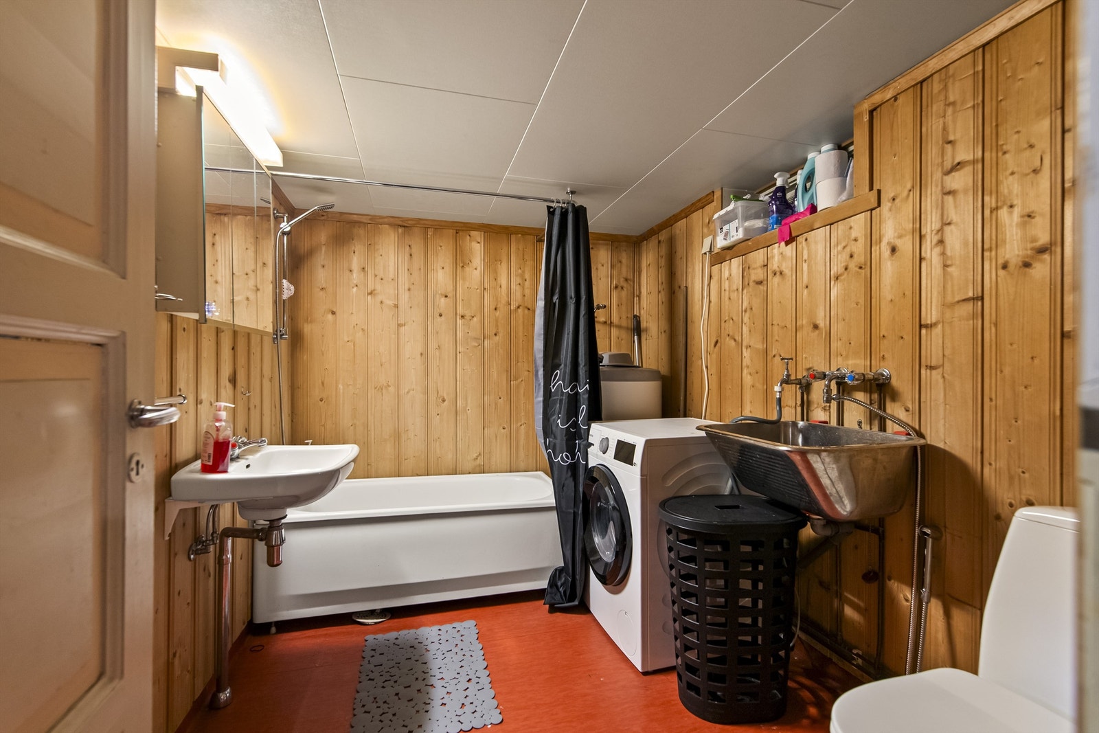 Praktisk bad i kjelleren med badekar, toalett og opplegg for vaskemaskin. Galleribilde