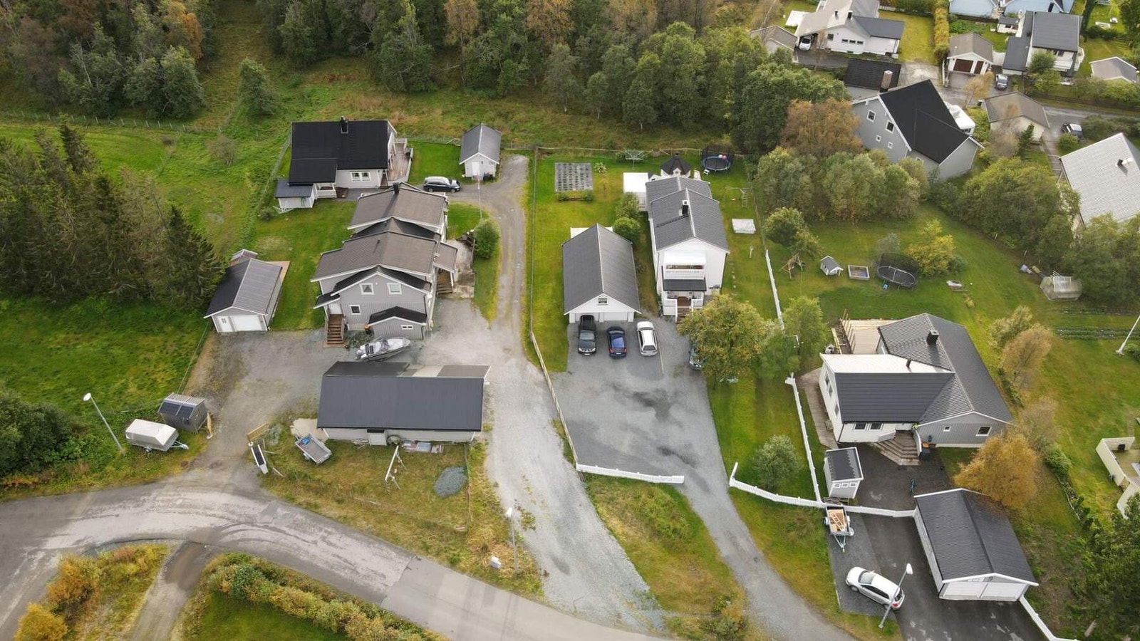 Eiendommen har en stor, gruset gårdsplass med rikelig parkeringsplass i tillegg til dobbelgarasjen. Galleribilde