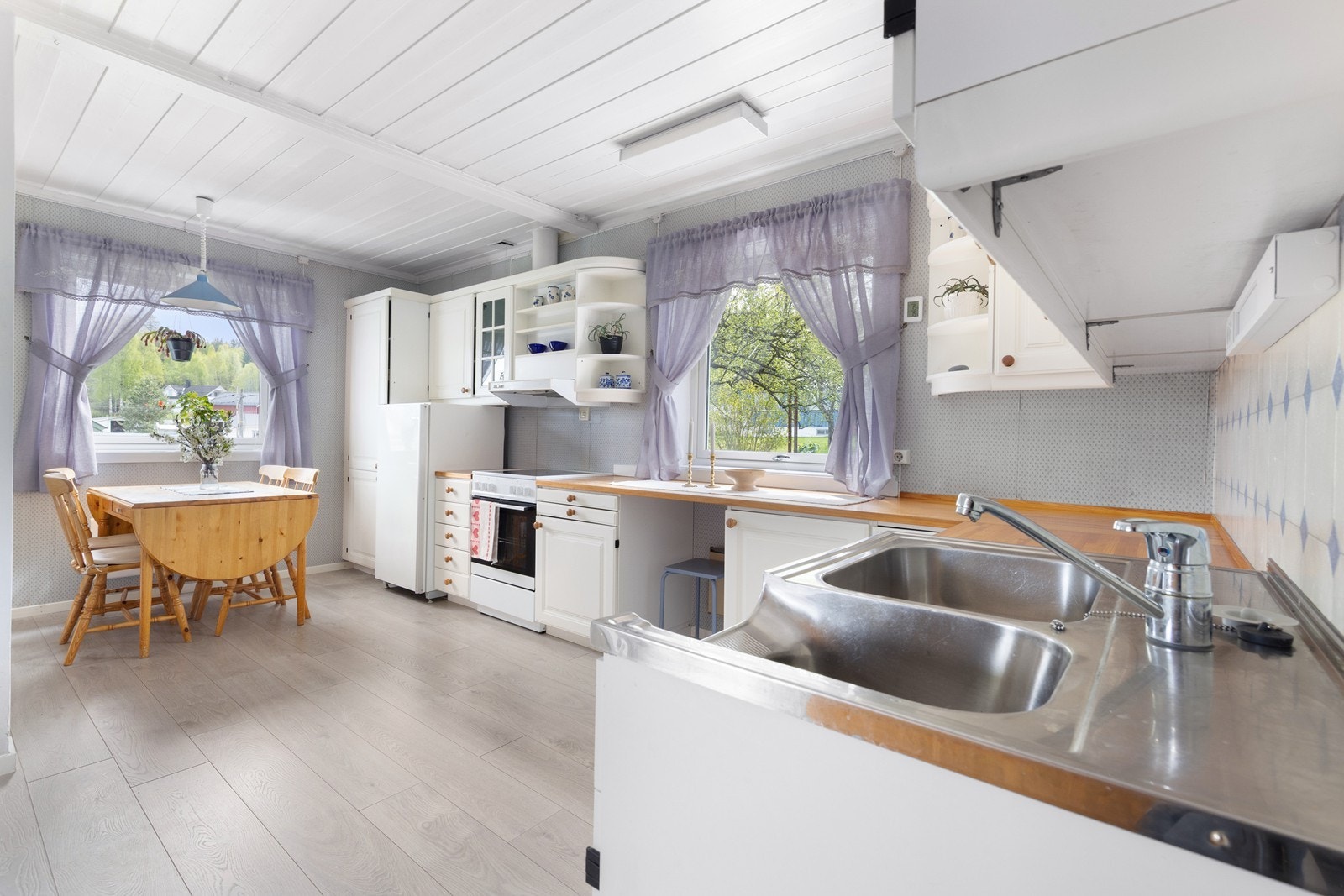 Kjøkkeninnredning med profilerte fronter og benkeplate i heltre. Kjøkkenventilator med avtrekk ut. Galleribilde