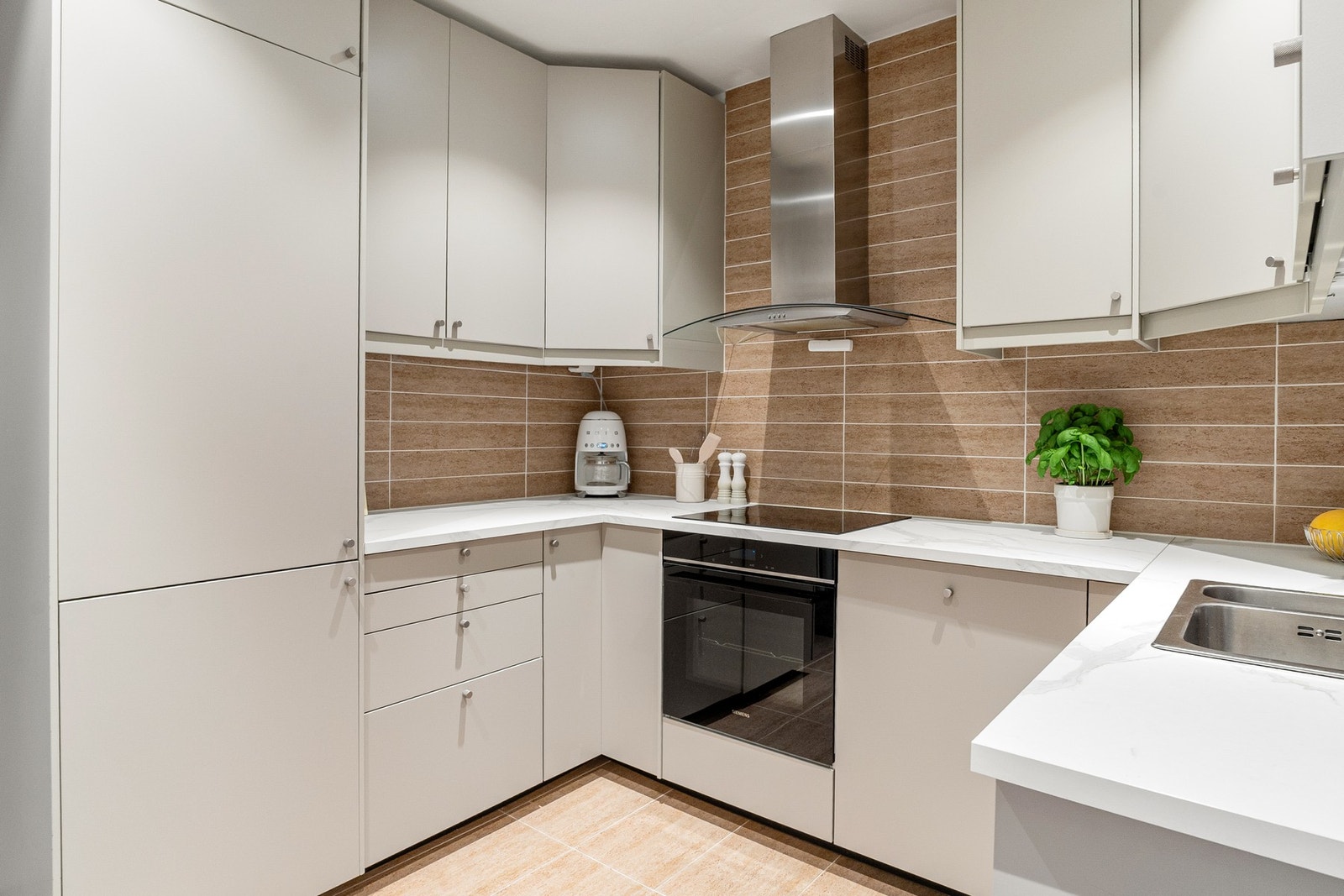 Innredningen er fra IKEA og har glatte, folierte fronter, laminat benkeplate med nedfelt kum i rustfritt stål. Galleribilde