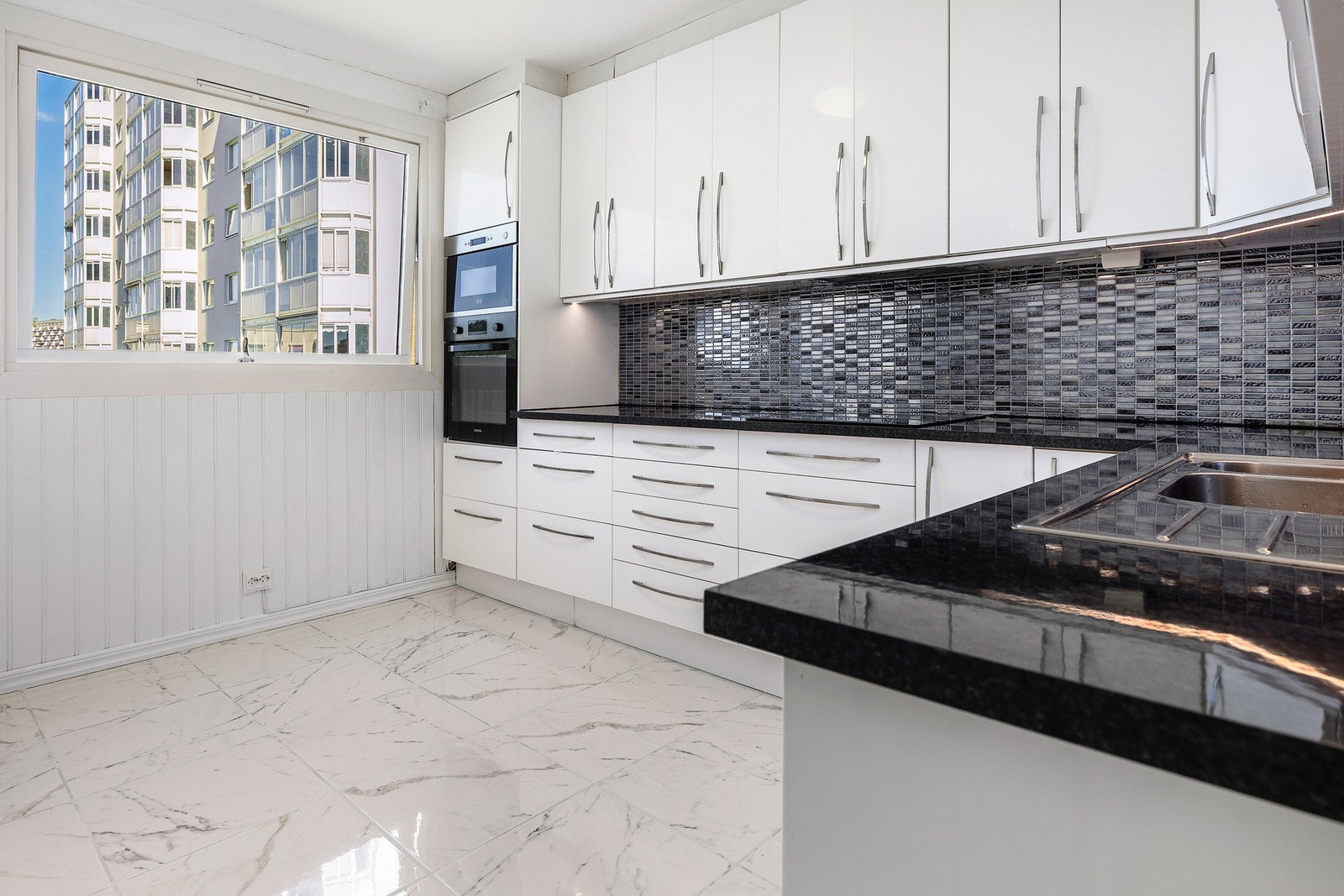 Separat kjøkken med moderne innredning med glatte fronter og laminat benkeplate. Galleribilde