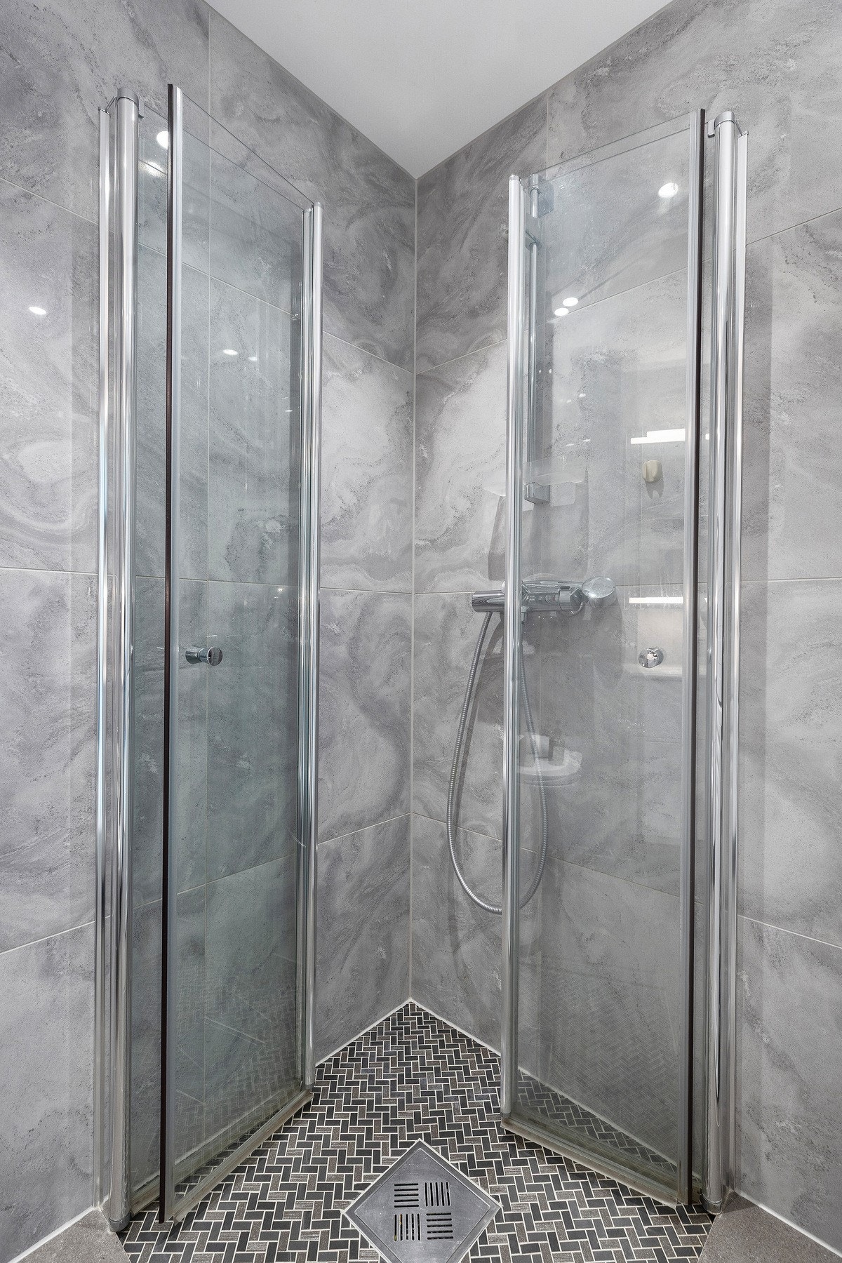 Badet er innredet med vegghengt toalett, servant med innredning og speil, dusjnisje med glassdører samt opplegg til vaskemaskin og tørketrommel. Galleribilde